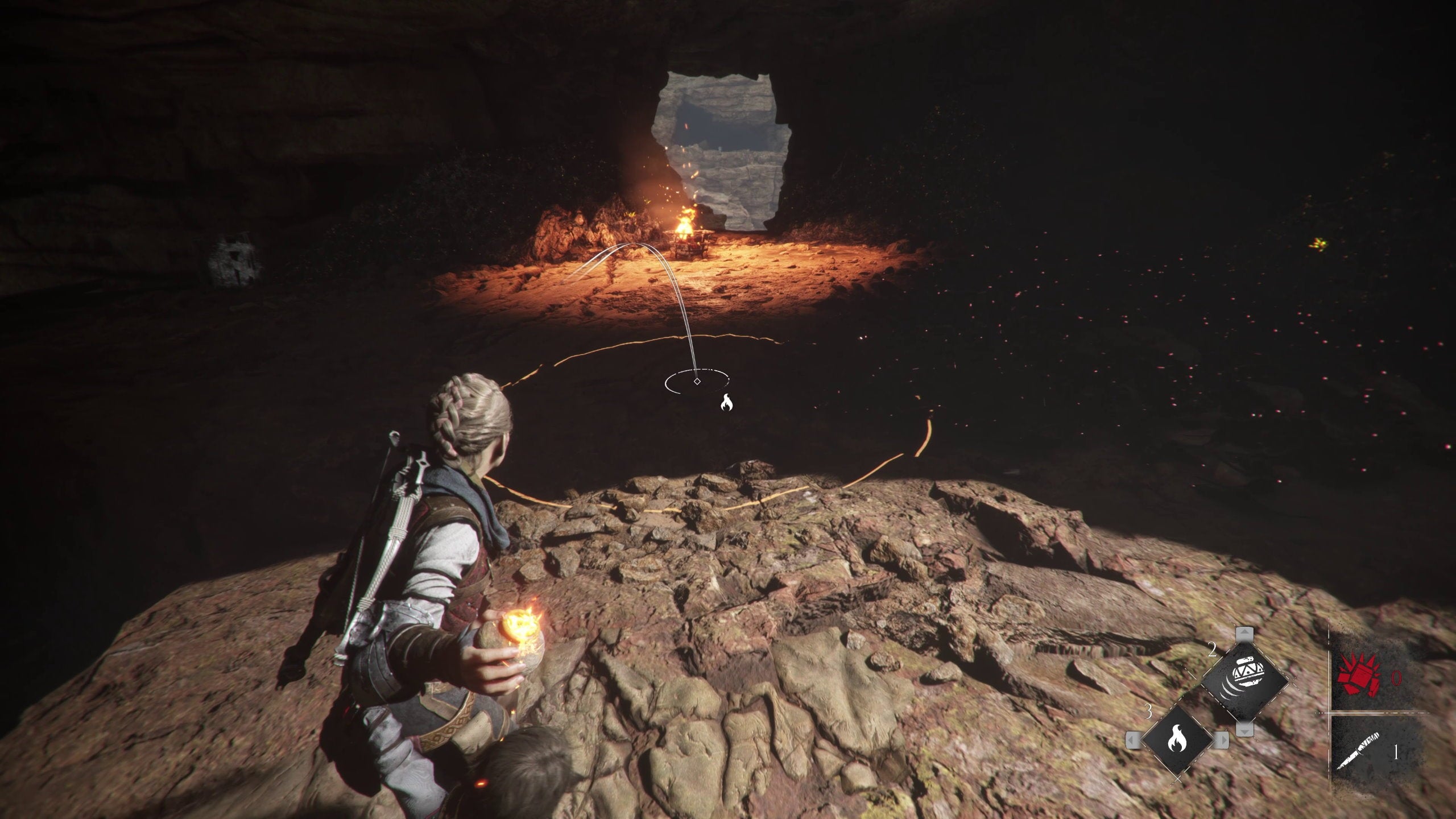 A young girl prepares to throw a flaming post inside a cave in A Plague Tale Requiem