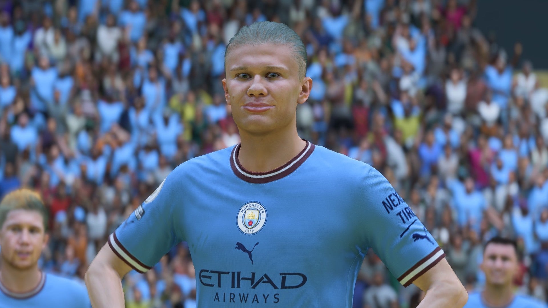 FIFA 23 screenshot showing Erling Haaland staring at the camera with his hands on his hips wearing a Man City kit, with a crowd of fans behind him.
