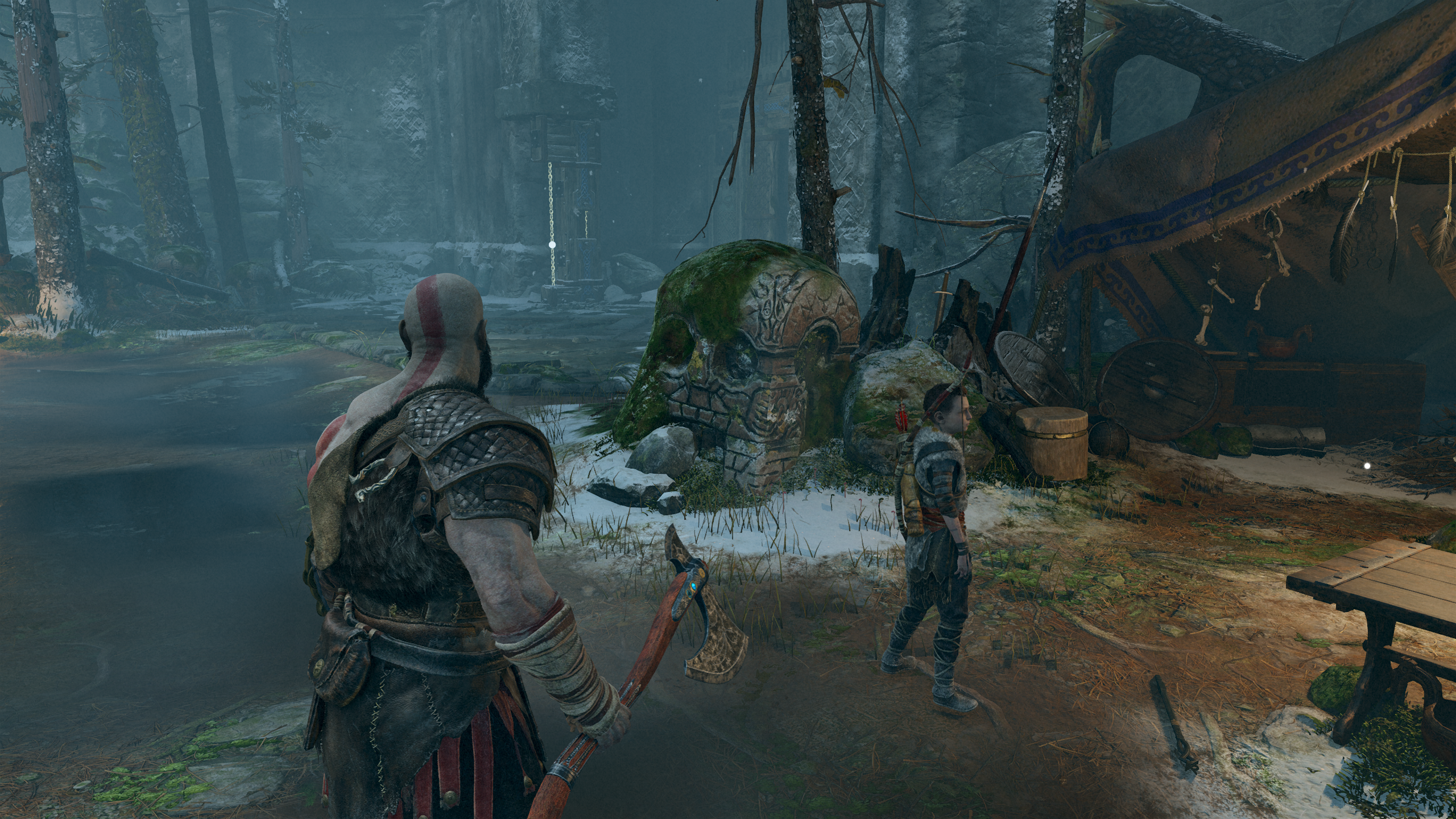 Kratos berdiri di depan batu berbentuk tengkorak di God of War.  Menampilkan resolusi 1440p asli.