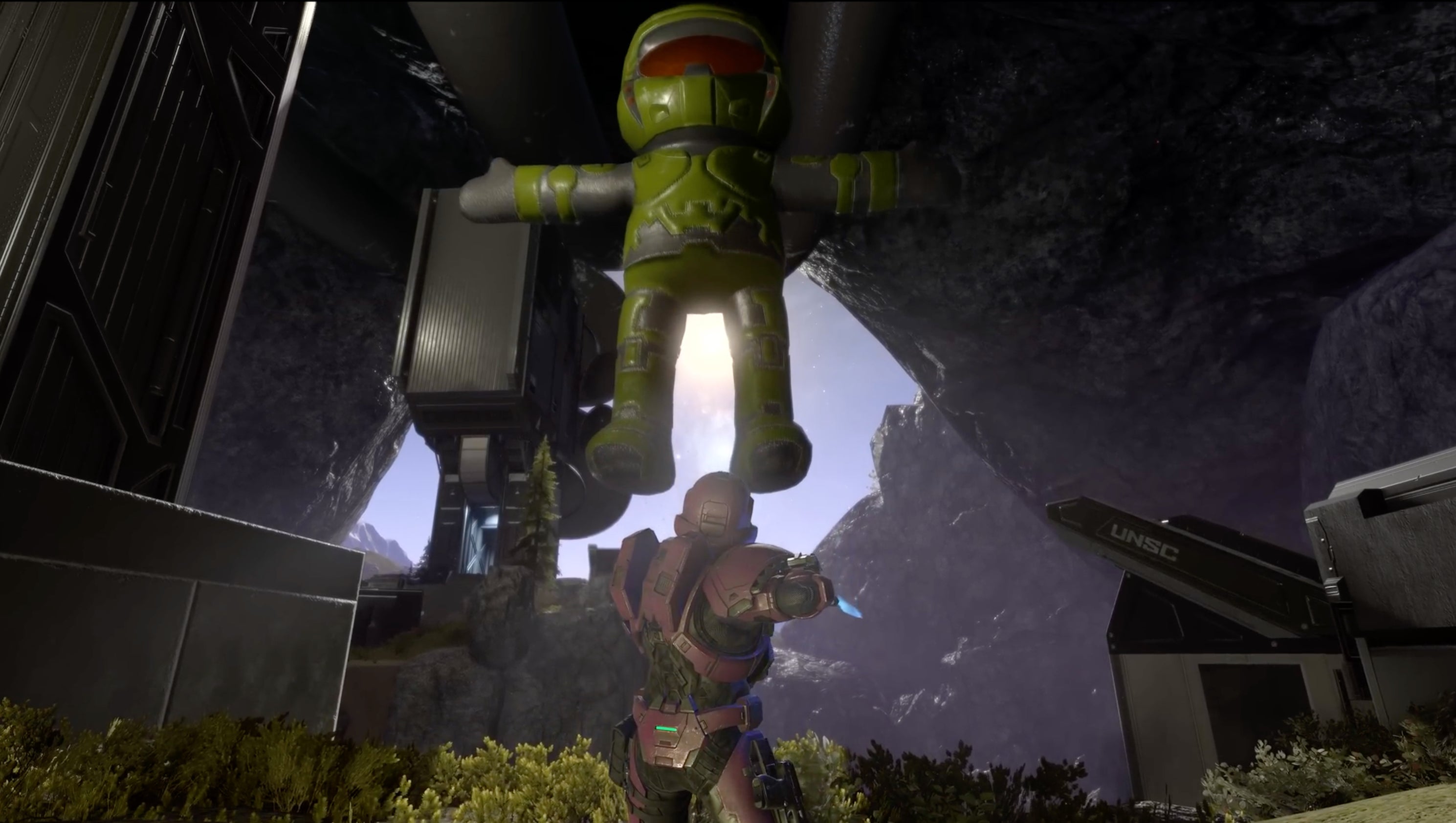 A large toy Master Chief hovers over a spartan.