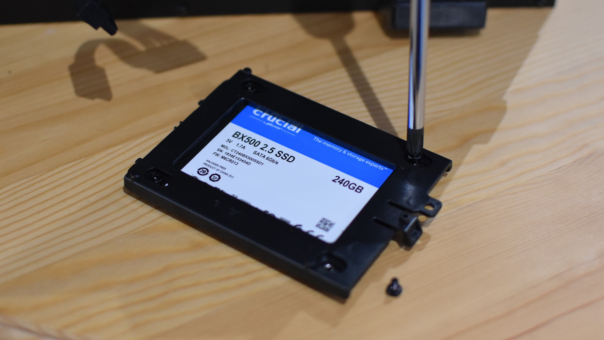 Step 2 of how to install a SATA SSD: attach the SSD to the mounting hardware, using screws if necessary.
