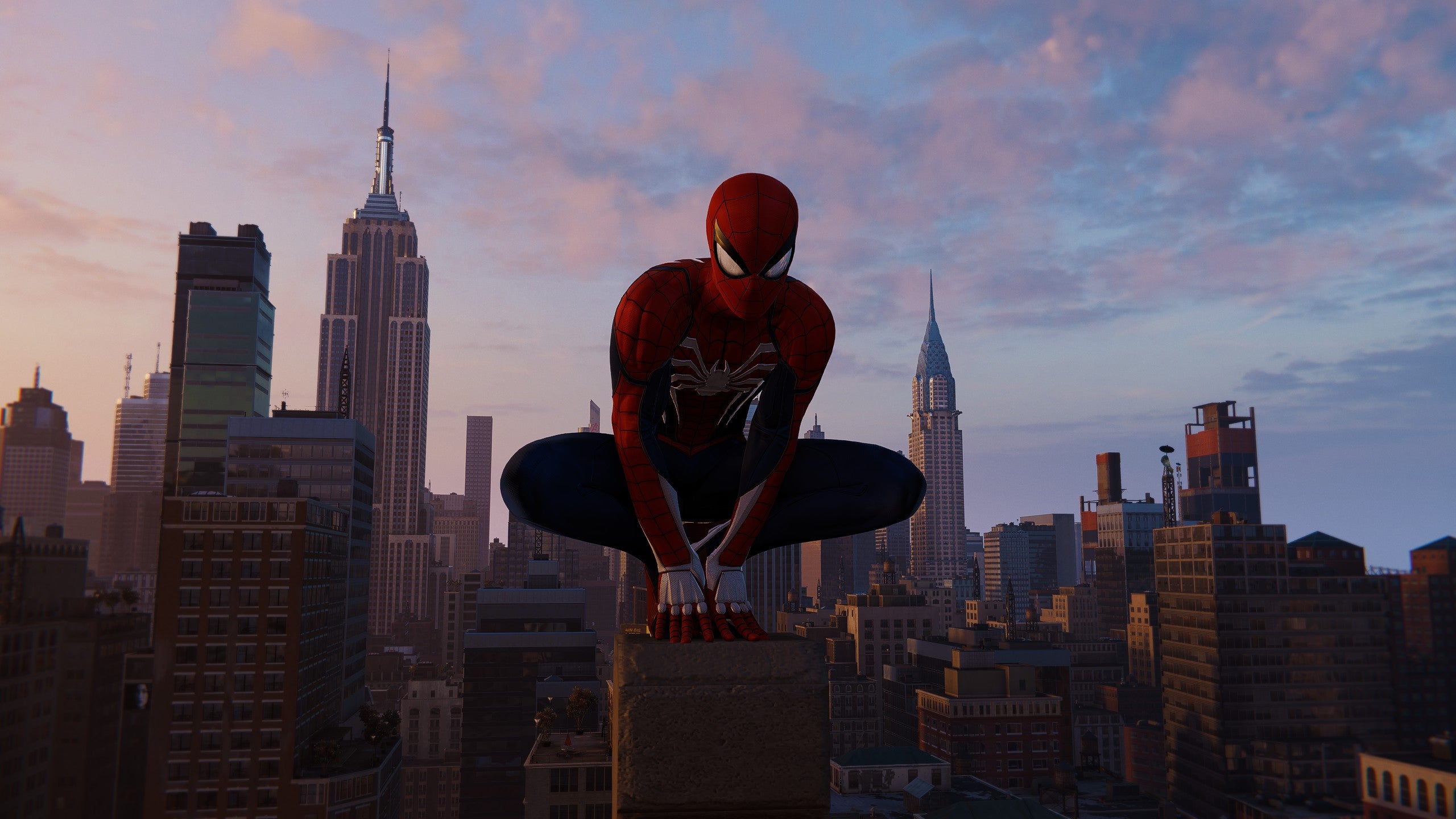 Spider-Man perches atop a building, New York skyline in the background, in Marvel's Spider-Man Remastered.