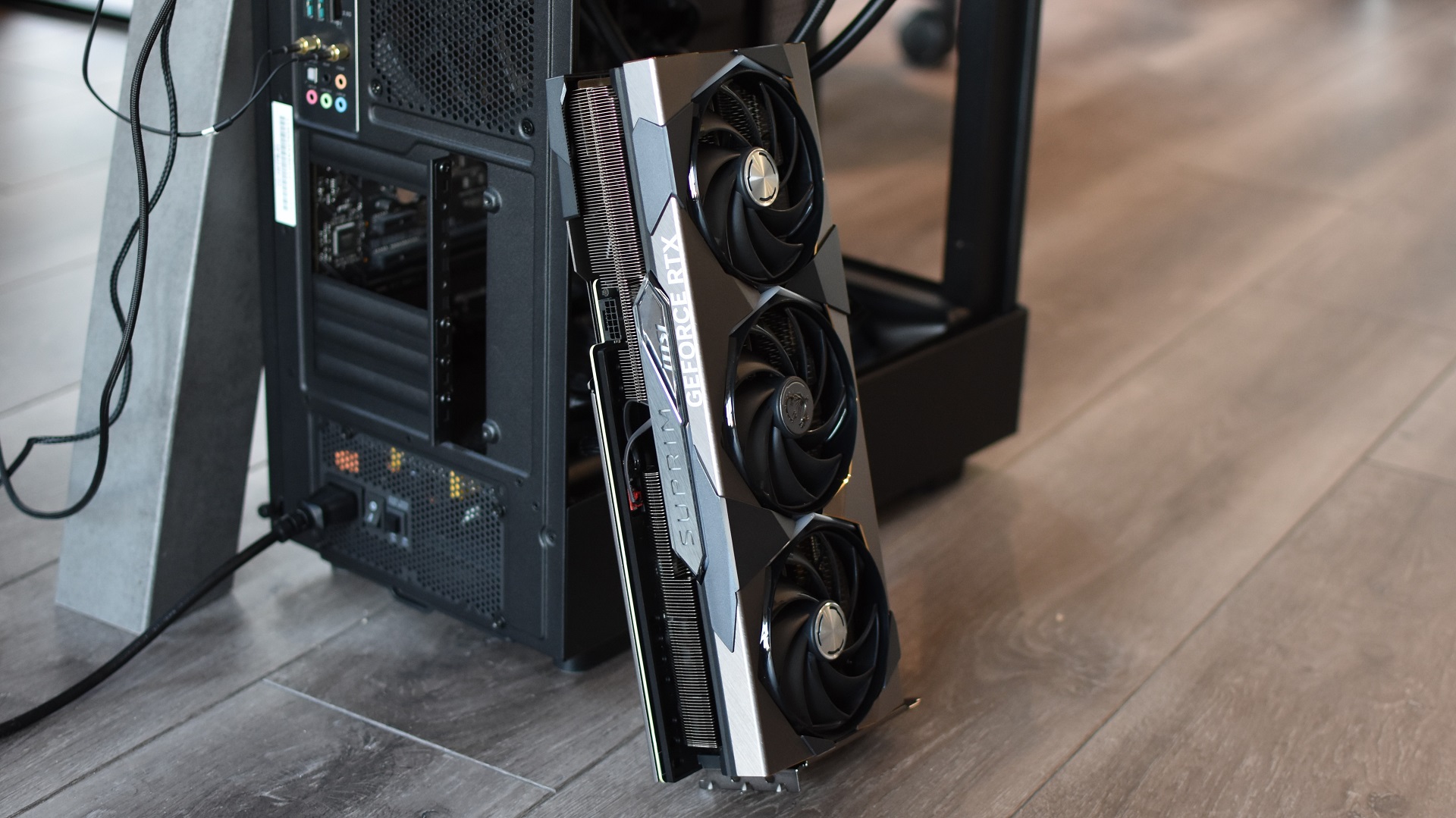 The MSI GeForce RTX 4070 Ti Suprim X 12G graphics card leaning against a PC case.
