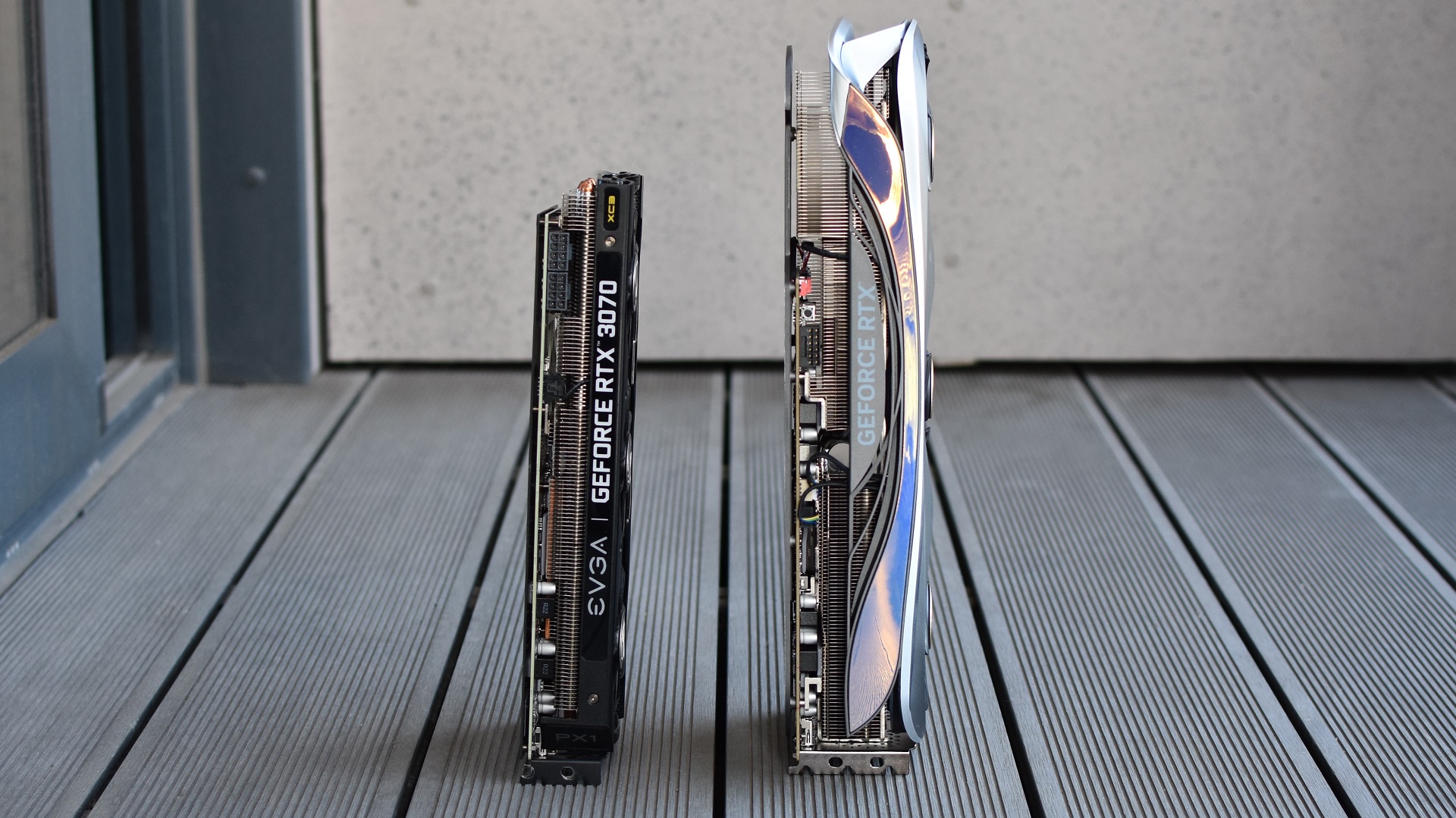 The Zotac Gaming GeForce RTX 4090 Amp Extreme Airo stood upright next to am RTX 3070, showing the size difference.