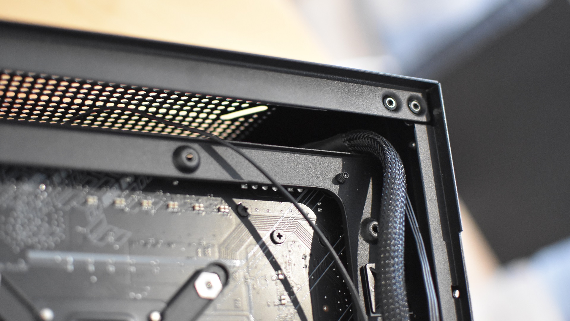 One of several cable routing holes in a gaming PC case.