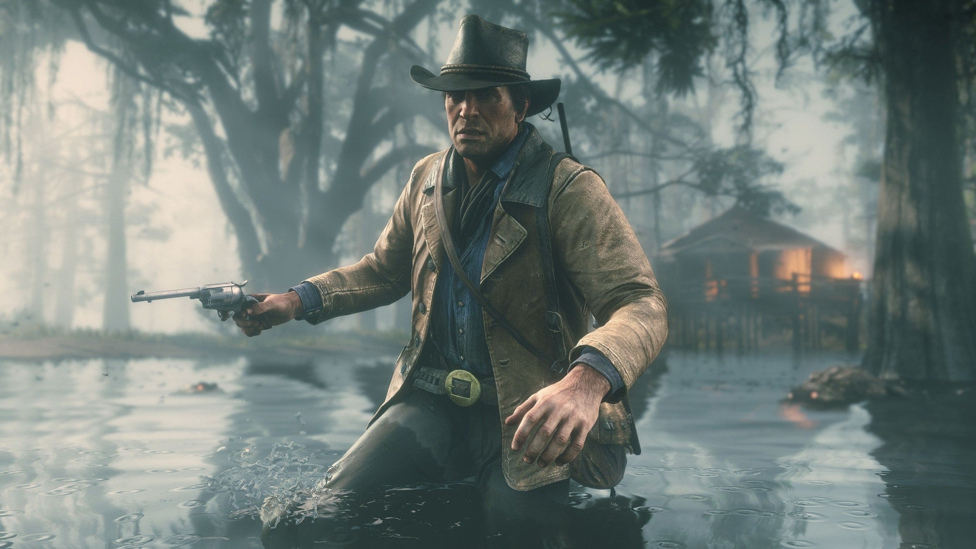 Red Dead Redemption 2 image showing Arthur Morgan wading through swampy water with trees and a lit hut in the background.