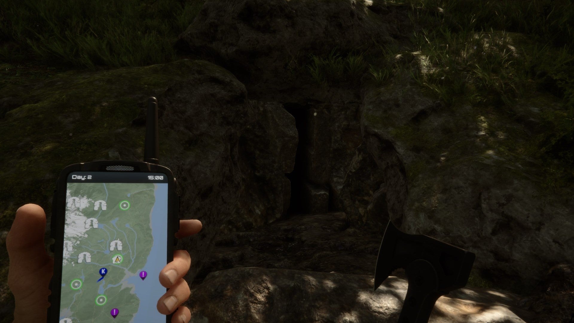 A player stares at a dark cave entrance while holding a GPS and an axe in Sons of the Forest.
