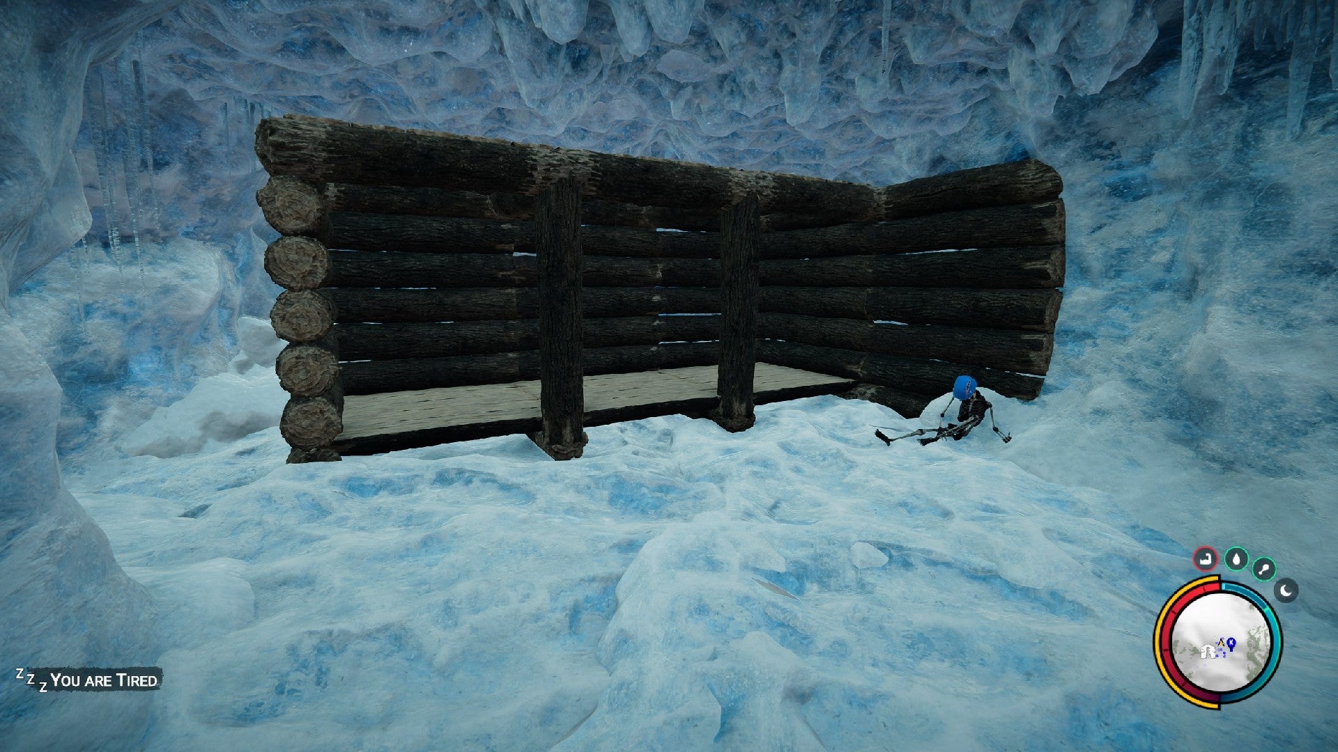 A small wooden base built inside an icy cave in Sons of the Forest.