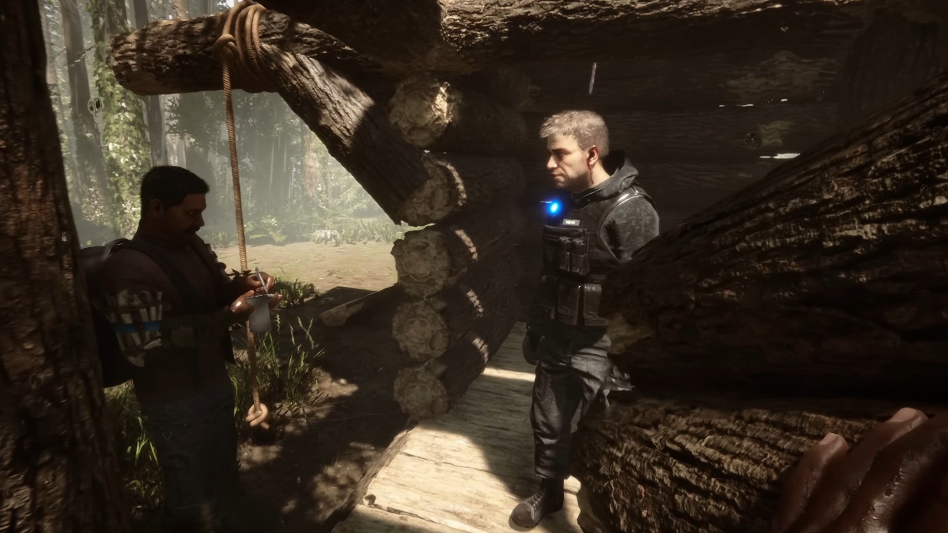 Sons of the Forest image showing two players stood in a shaded cabin together in the woods.