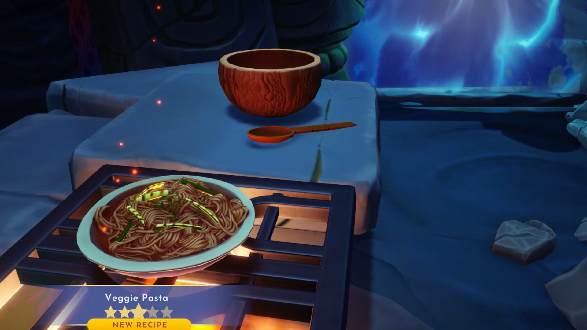Captura de pantalla de Disney Dreamlight Valley que muestra una comida de pasta vegetariana cocinada, que está en la estufa de un horno en una cueva oscura.