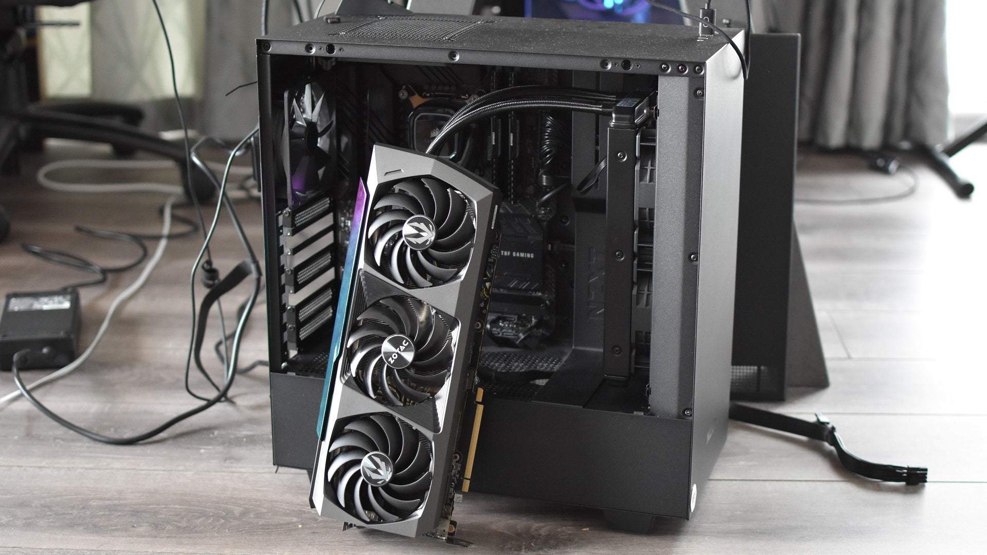 The Zotac GeForce RTX 3090 Ti AMP Extreme Holo graphics card propped up against an open PC case.