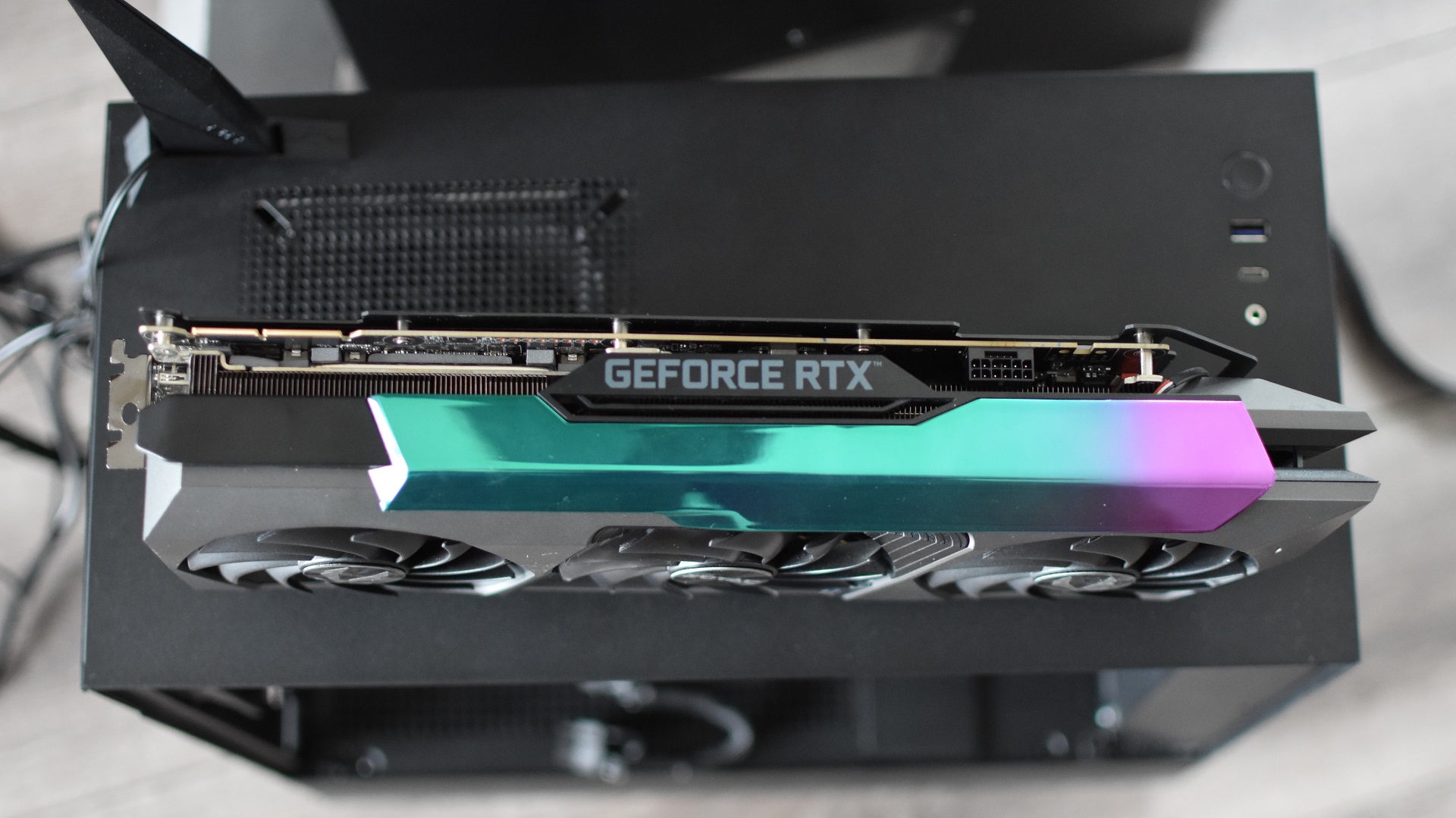 A top-down view of the Zotac GeForce RTX 3090 Ti AMP Extreme Holo graphics card as it sits sideways on top of a PC case.