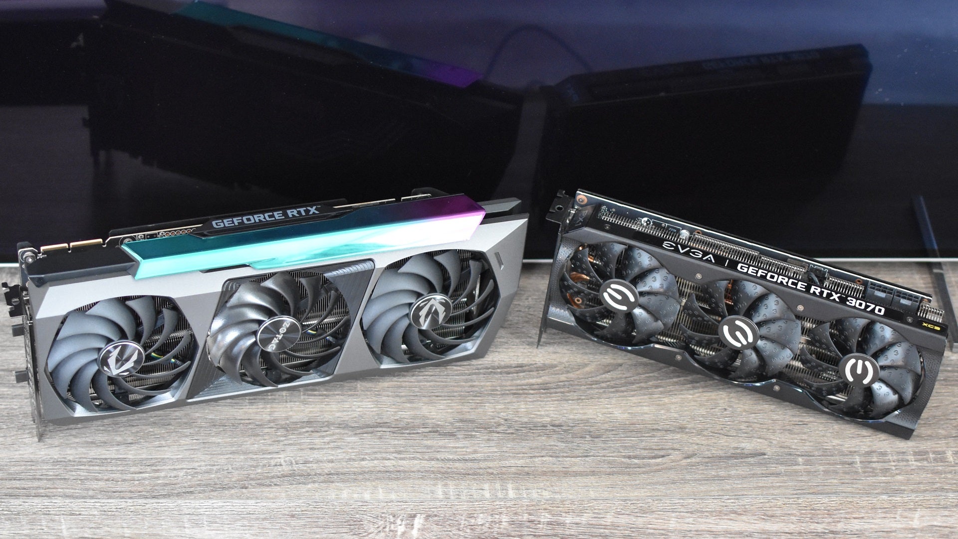 The Zotac GeForce RTX 3090 Ti AMP Extreme Holo graphics card next to an RTX 3070, showing the size difference between the two.