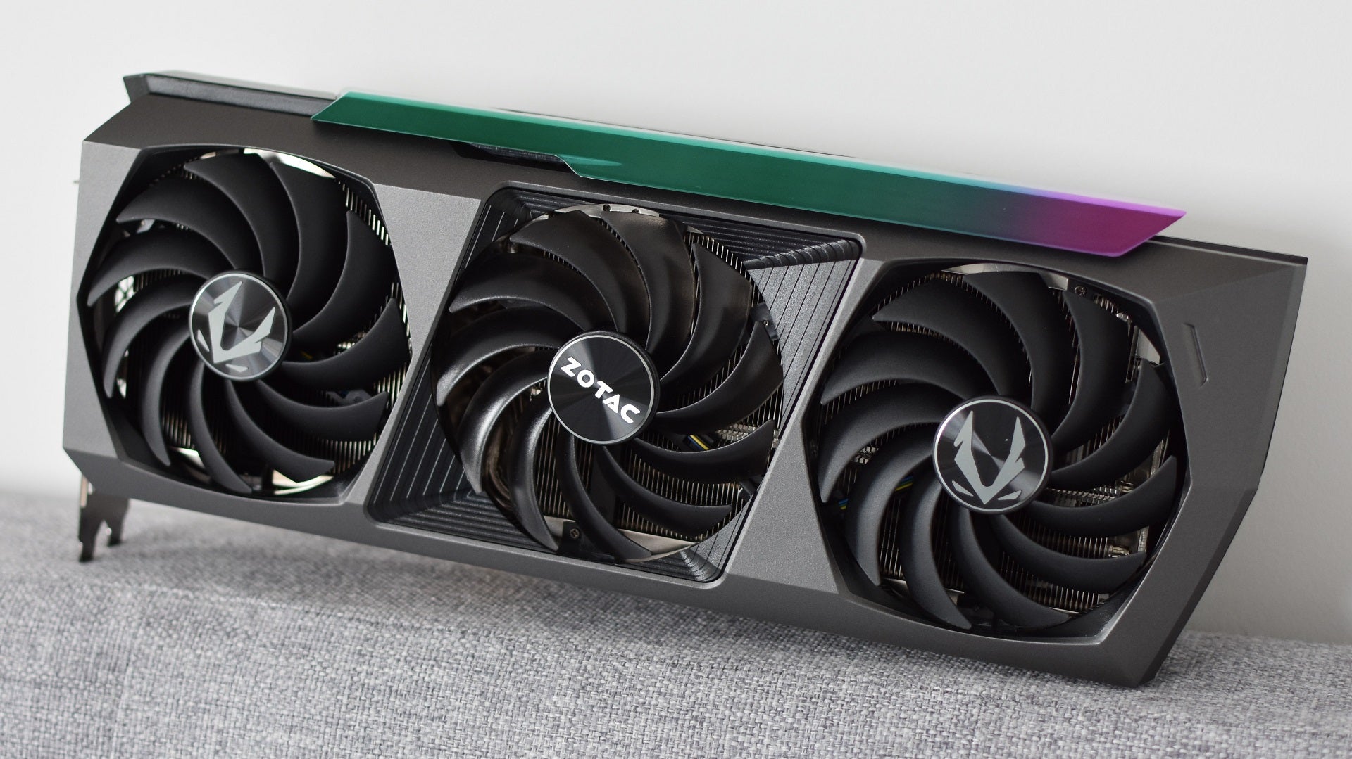 The Zotac GeForce RTX 3090 Ti AMP Extreme Holo graphics card, sitting sideways with its fans facing the camera.