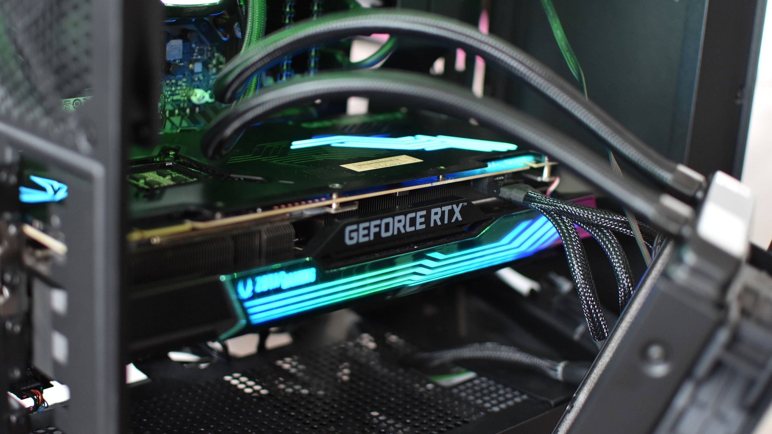 A close up of a Zotac Gaming GeForce RTX 3090 Ti AMP Holo graphics card running inside a PC case.