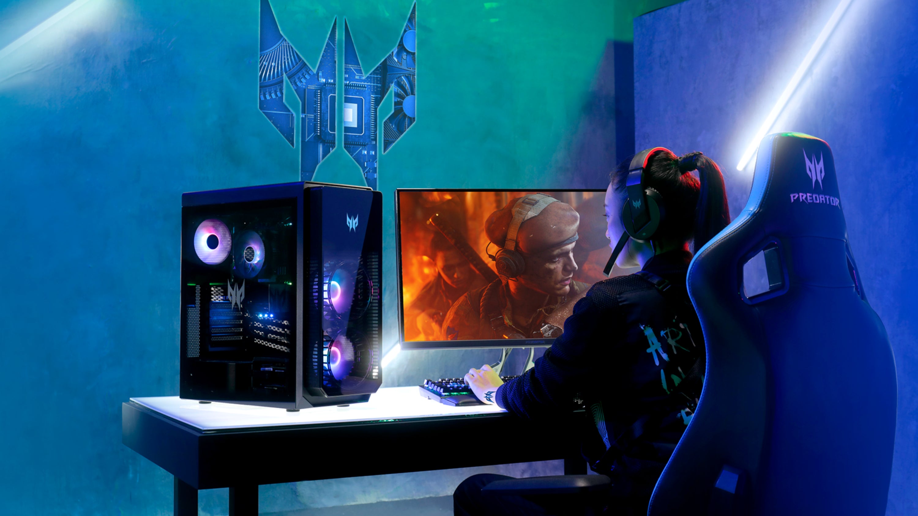 The Acer Predator Orion 5000 is sitting on a desk next to a woman playing games on it.
