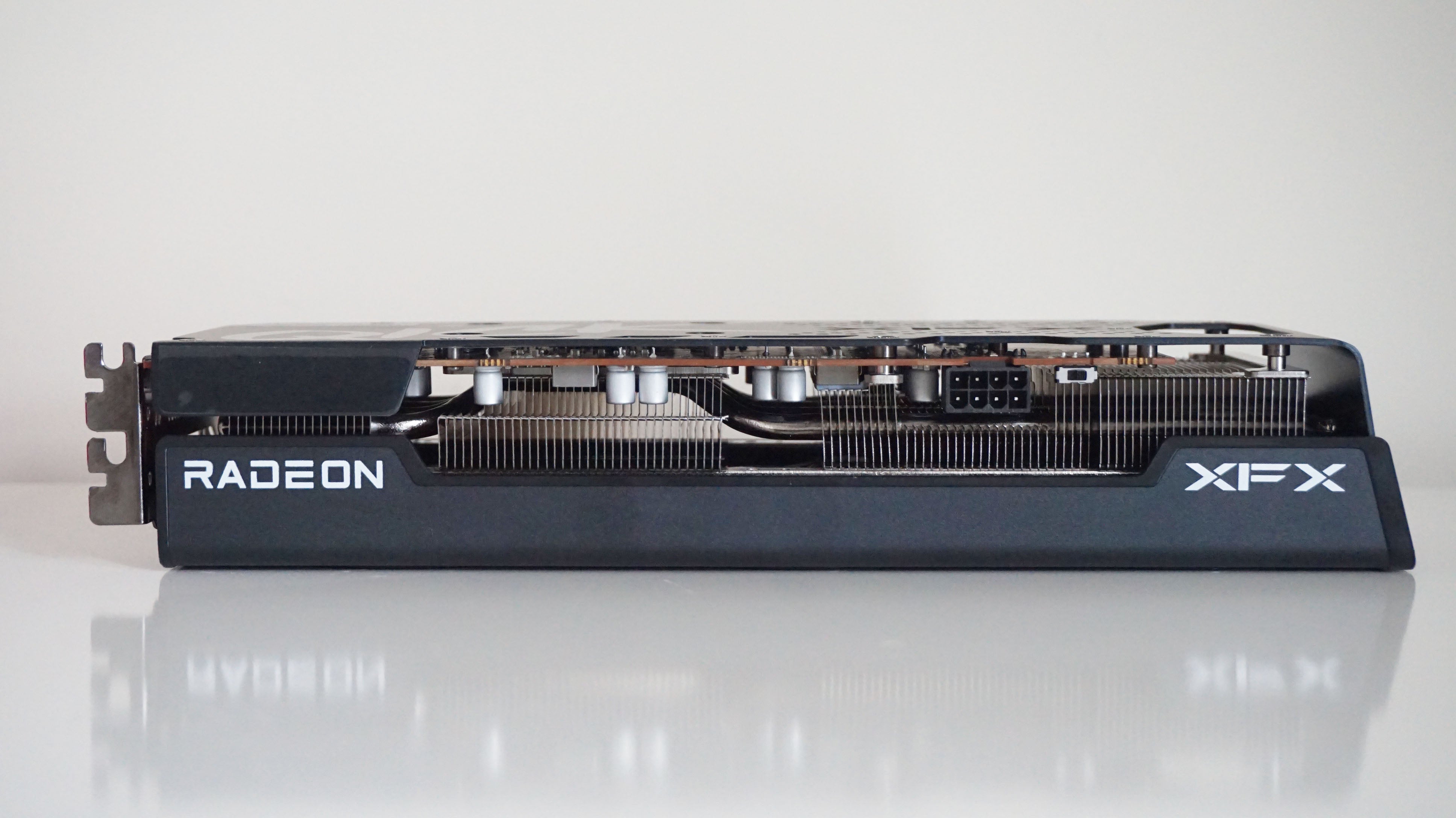 A photo of the AMD Radeon RX 6600 XT graphics card on its side, showing its single 8-pin power connector