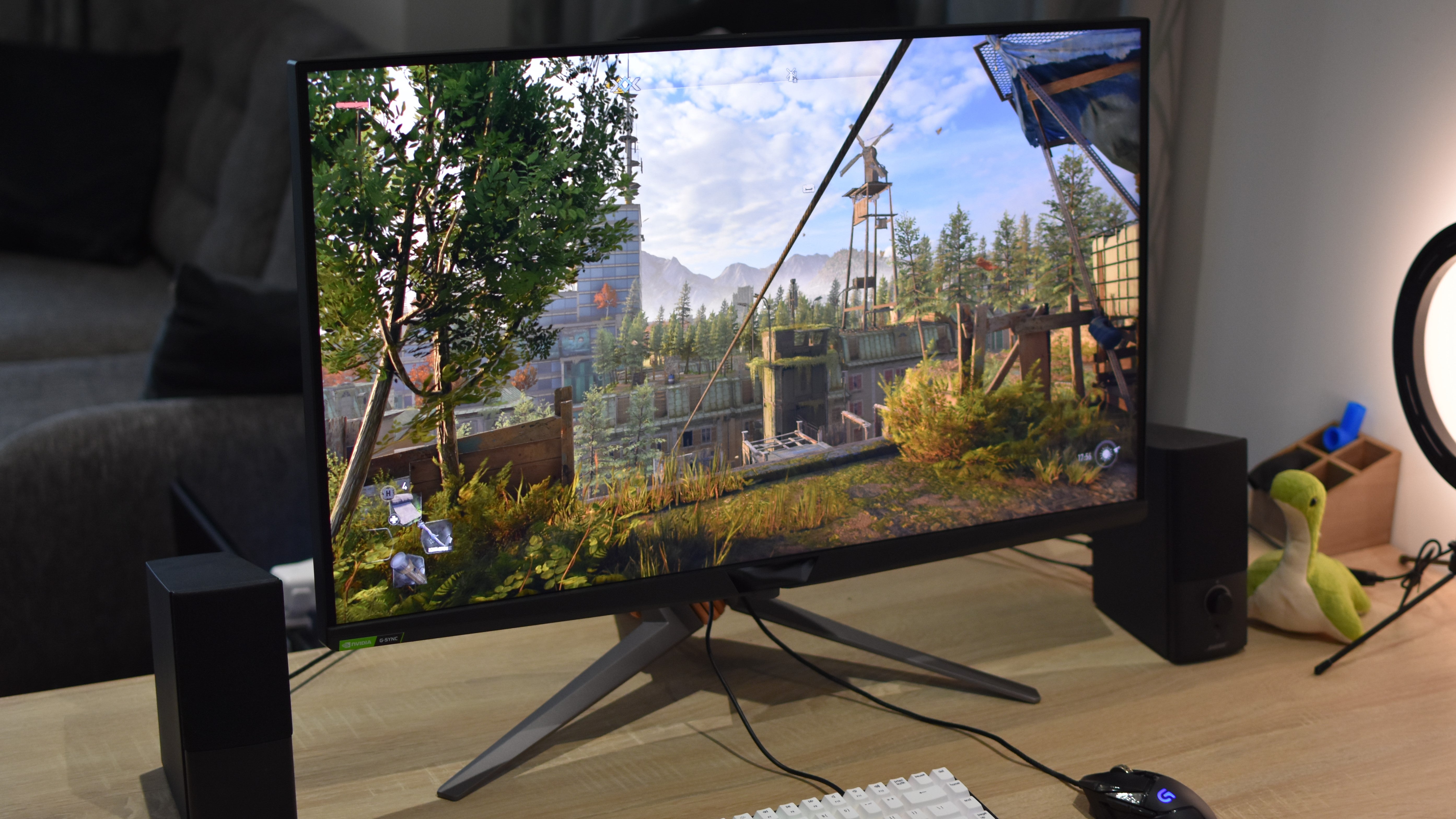 The Asus ROG Swift PG32UQX gaming monitor on a desk, running Dying Light 2.