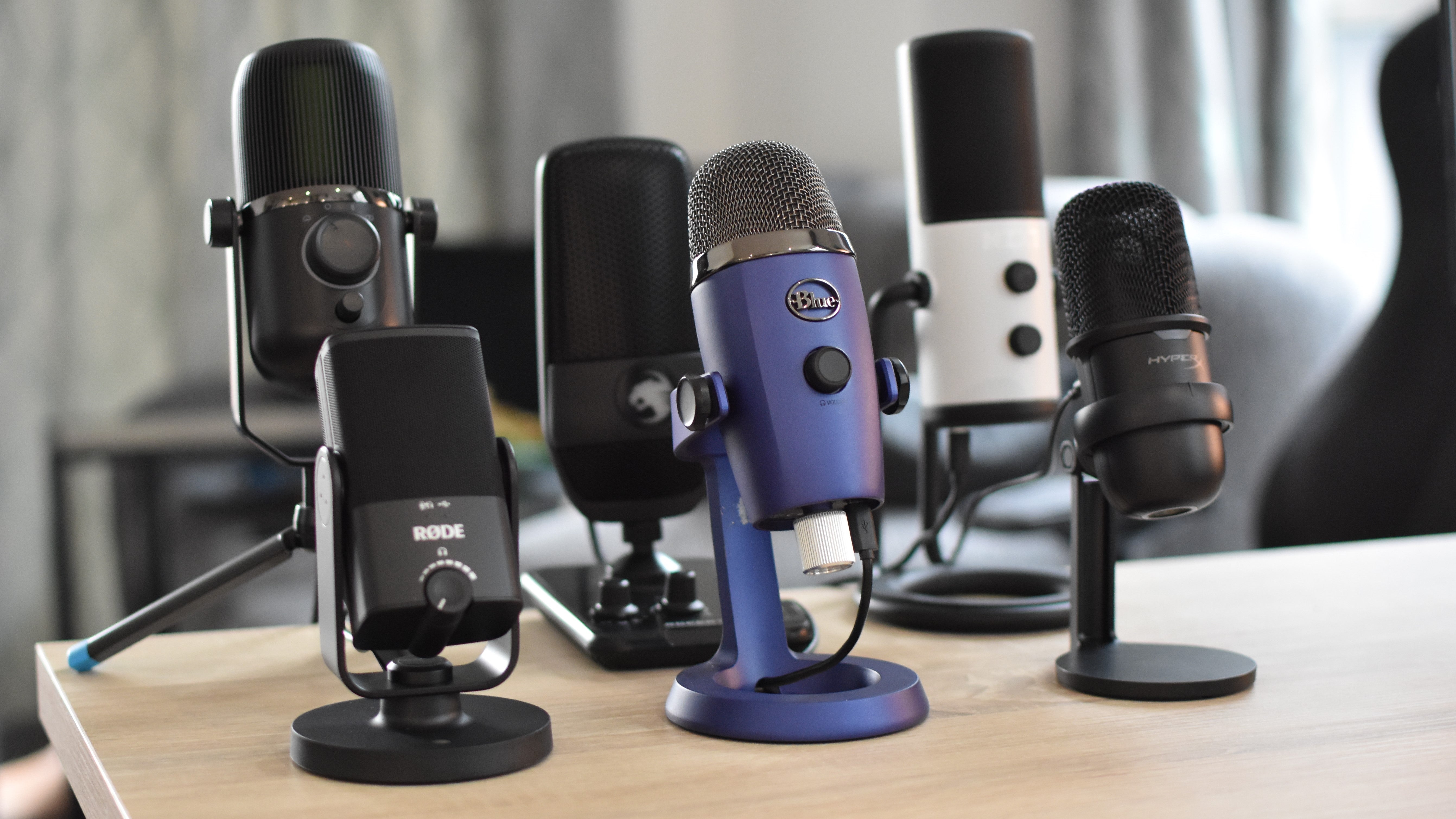 A collection of some of the best microphones for gaming, arranged on a desk.
