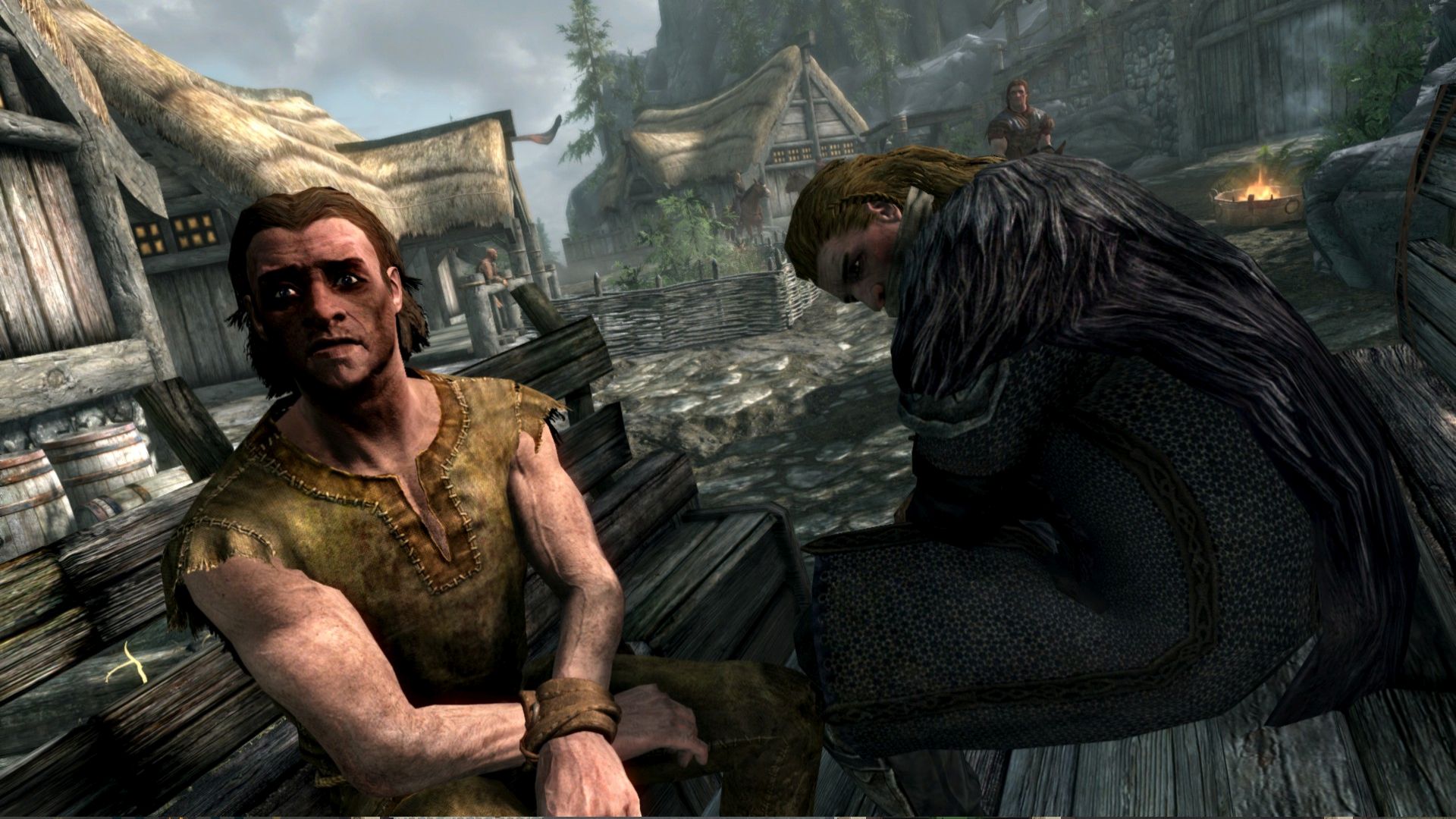 Two men in rags sit in a wooden cart in The Elder Scrolls V: Skyrim