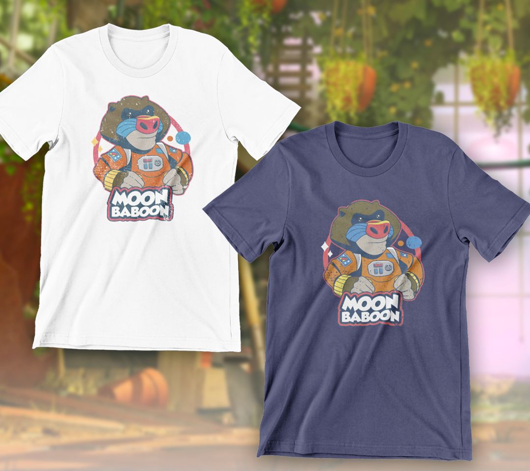 T-shirt merch putih dan biru untuk It Takes Two, keduanya dengan logo Babon Bulan dari babon mainan dalam pakaian luar angkasa
