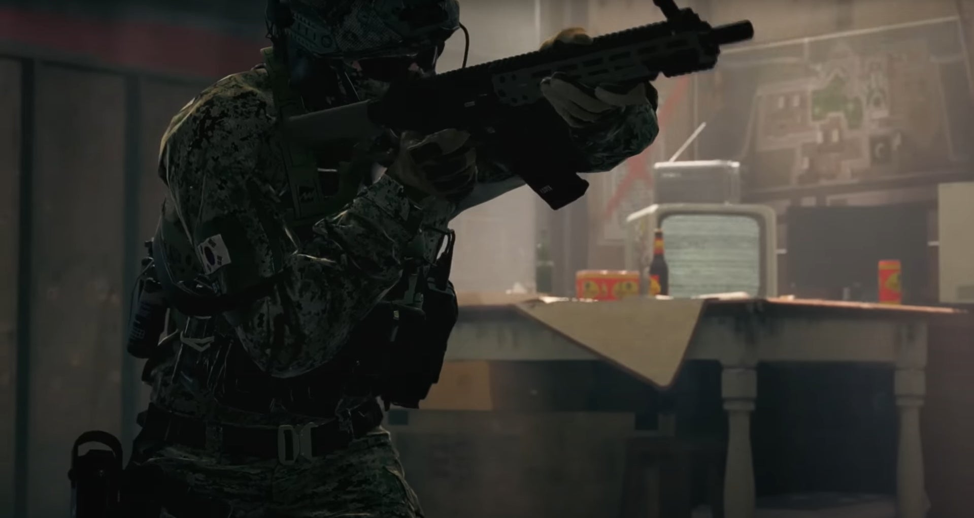 A soldier with a gun in a house next to a cluttered table with a TV showing static in Modern Warfare 2.