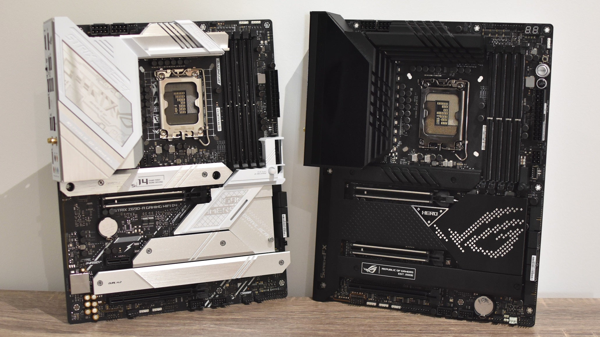 The Asus ROG Strix Z690-A Gaming WiFi D4 propped upright next to an Asus ROG Maximus Z690 Hero motherboard.