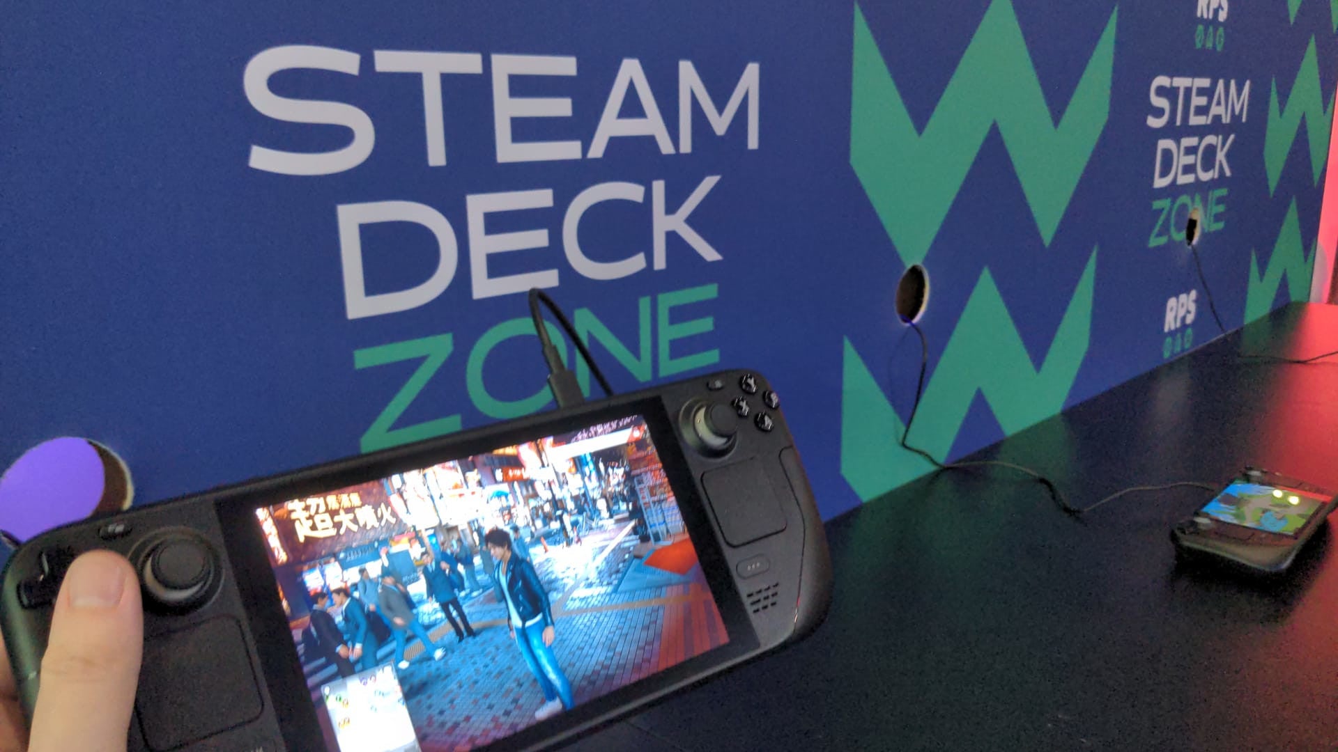 A photo of playing Judgment on a Steam Deck in the Steam Deck Zone at EGX 2022.