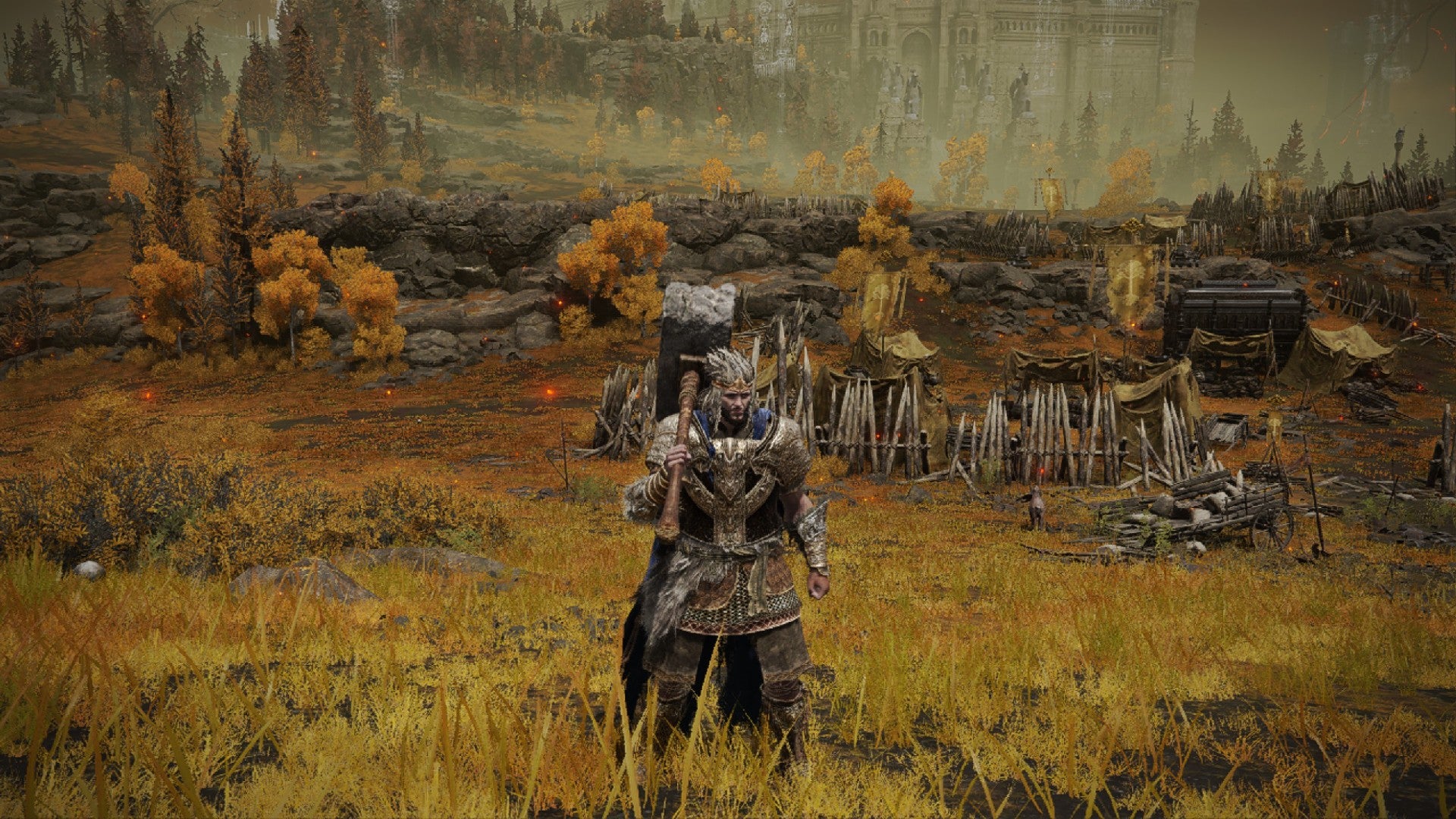 Elden Ring player standing on an Autumnal field wearing warrior clothing and wielding a large Brick Hammer weapon