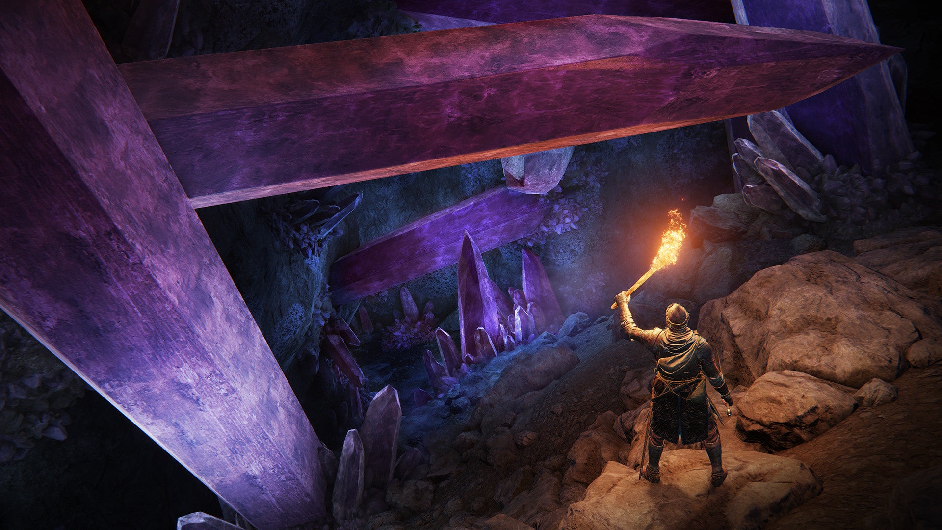 An Elden Ring character holds up a torch to illuminate a cavern filled with giant gemstones.