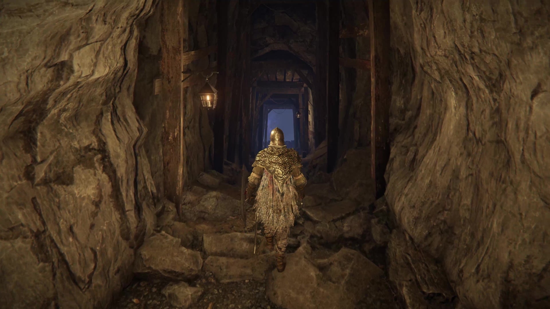 A screenshot from Elden Ring which shows the player cautiously wander through an underground tunnel.