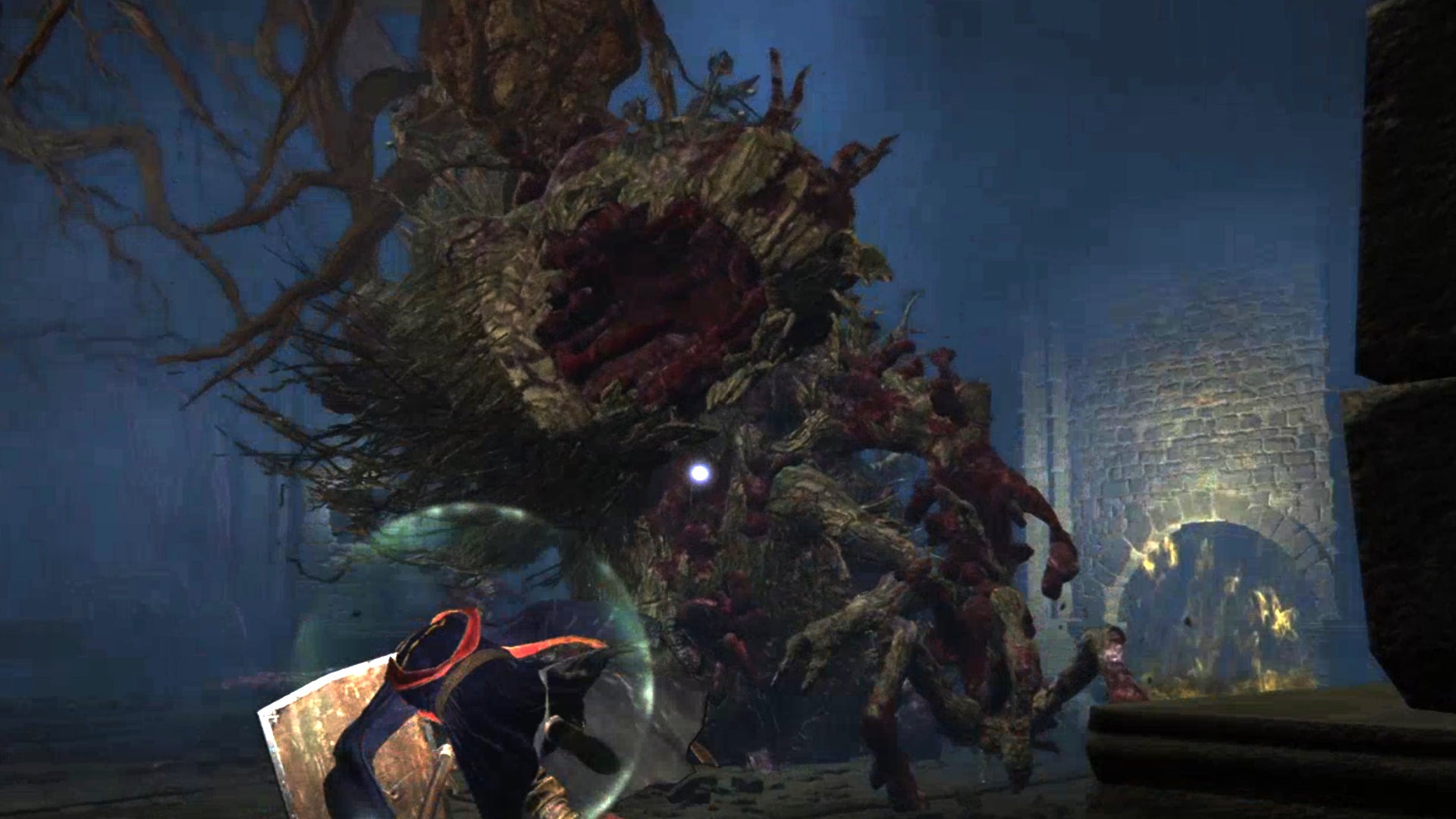 The Ulcerated Tree Spirit, a boss in Elden Ring, rears up and bites down towards the player.