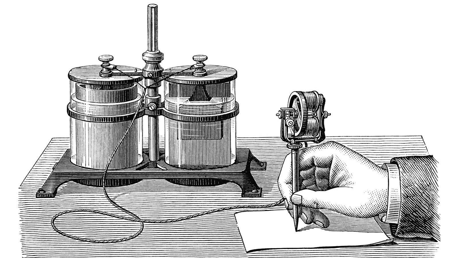 A hand is seen writing on a stencil with Edison’s electric pen connected to a wet cell battery. Edison’s electric pen was a device used for duplicating handwritten or hand-drawn documents.