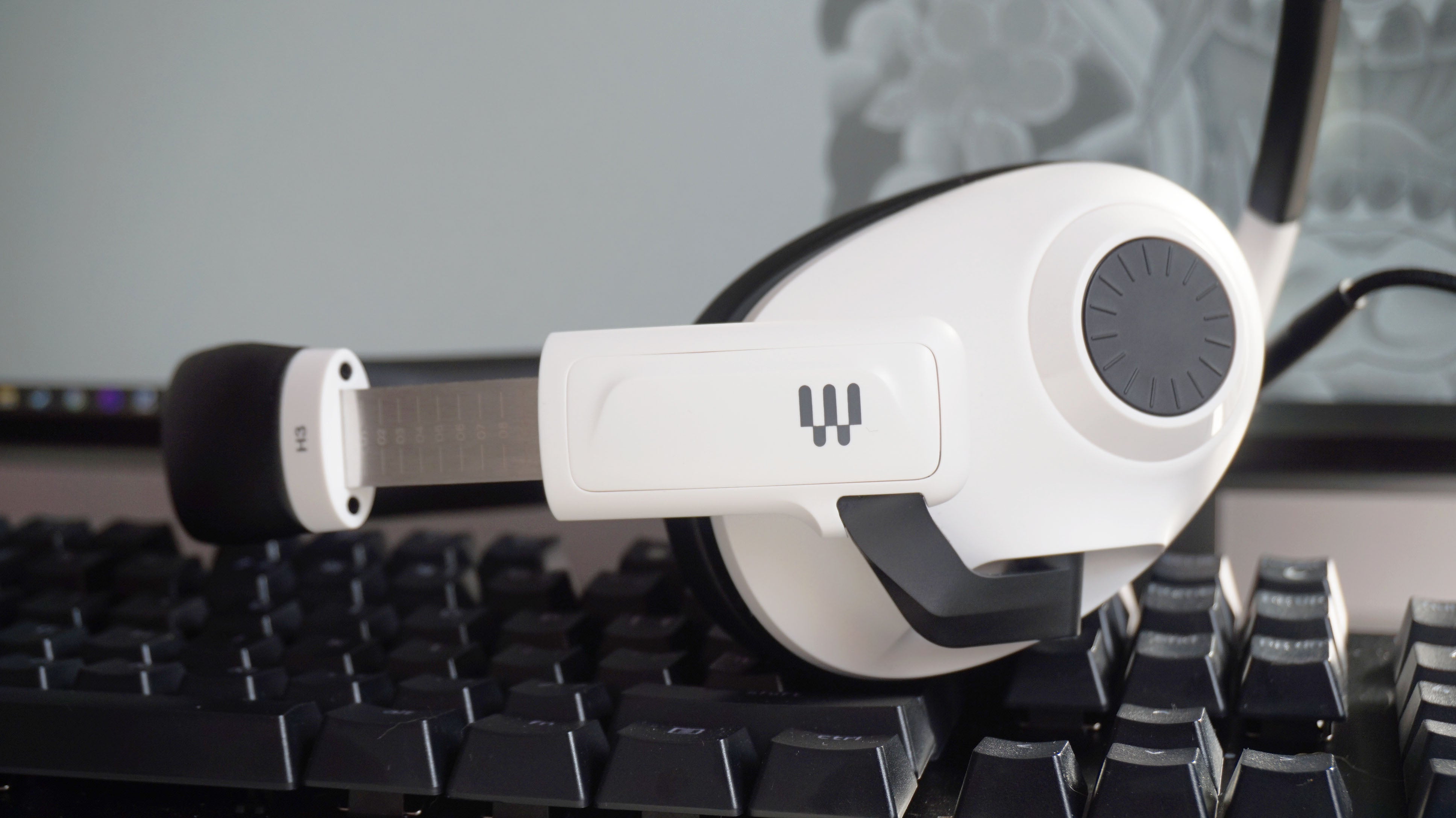 The EPOS H3 gaming headset from the side, showing the volume dial and adjustable steel headband slider