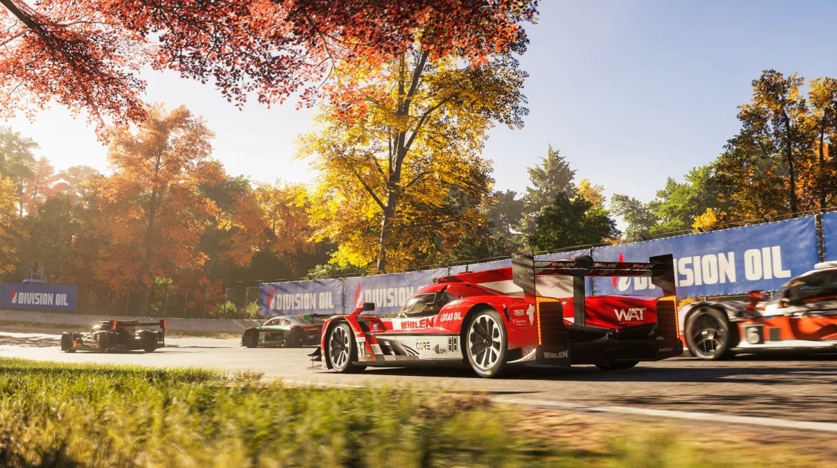 A shiny red car rounds a corner backed by other cars and trees in the new Forza Motorsport.