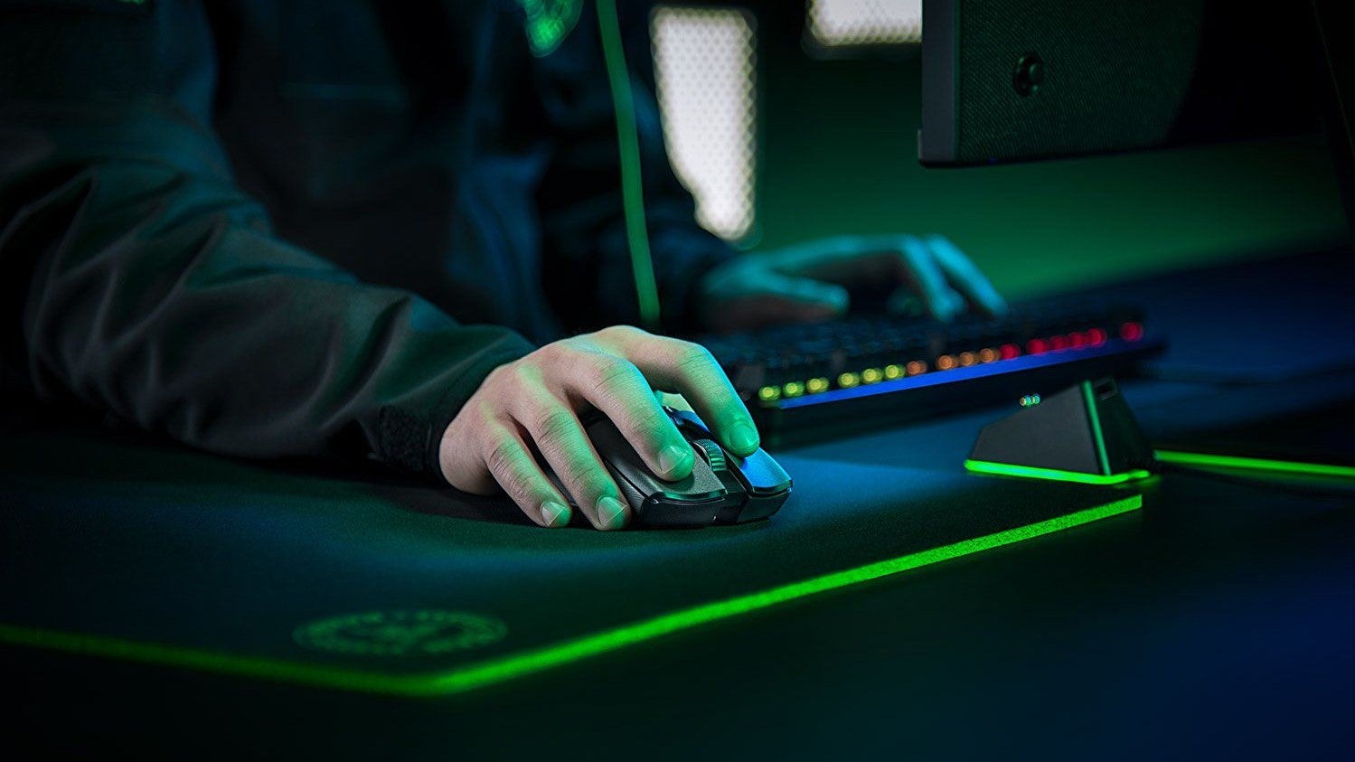 A man uses a gaming mouse on an RGB-lit mousemat.