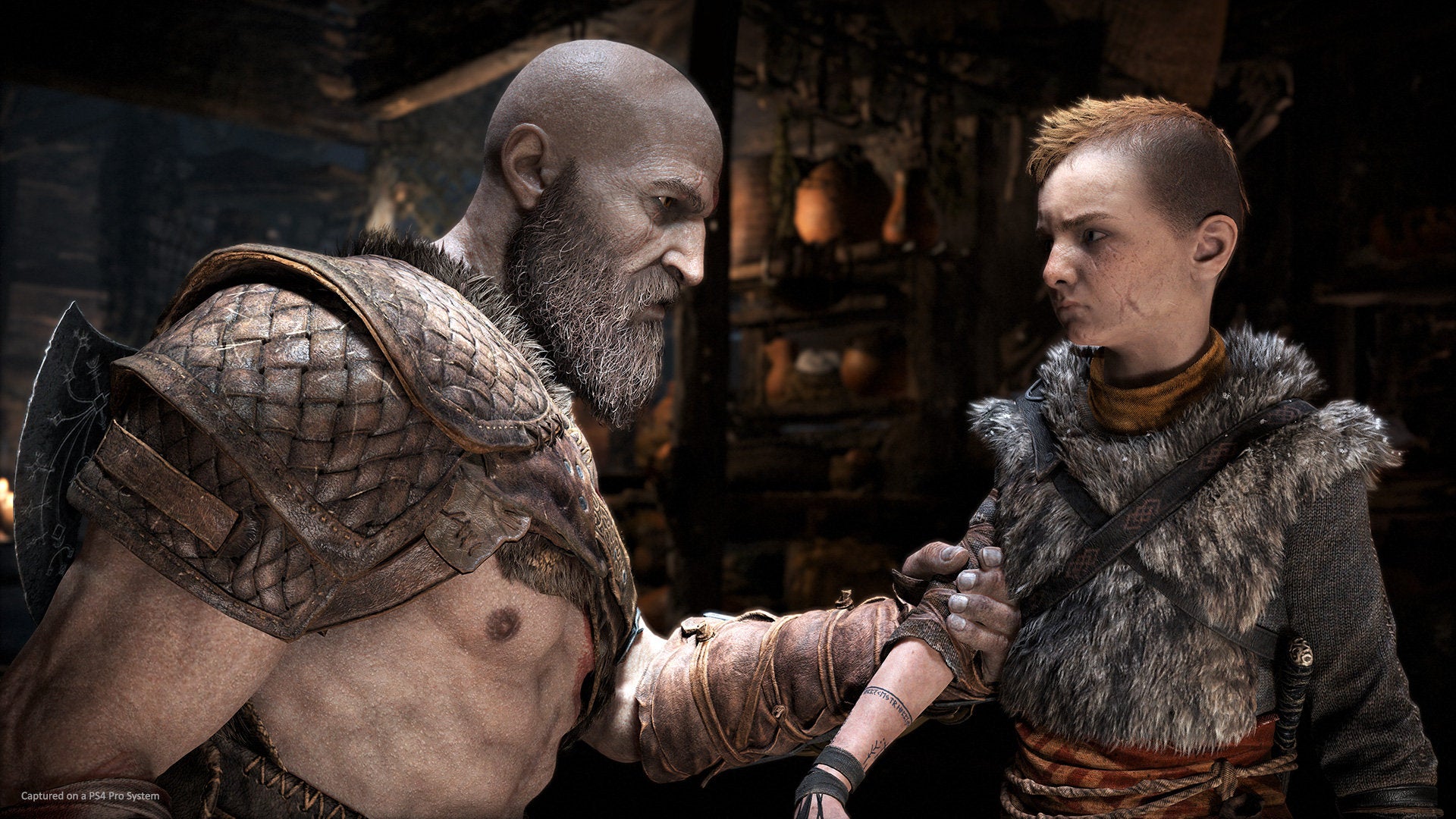 Kratos and boy in a God of War screenshot.