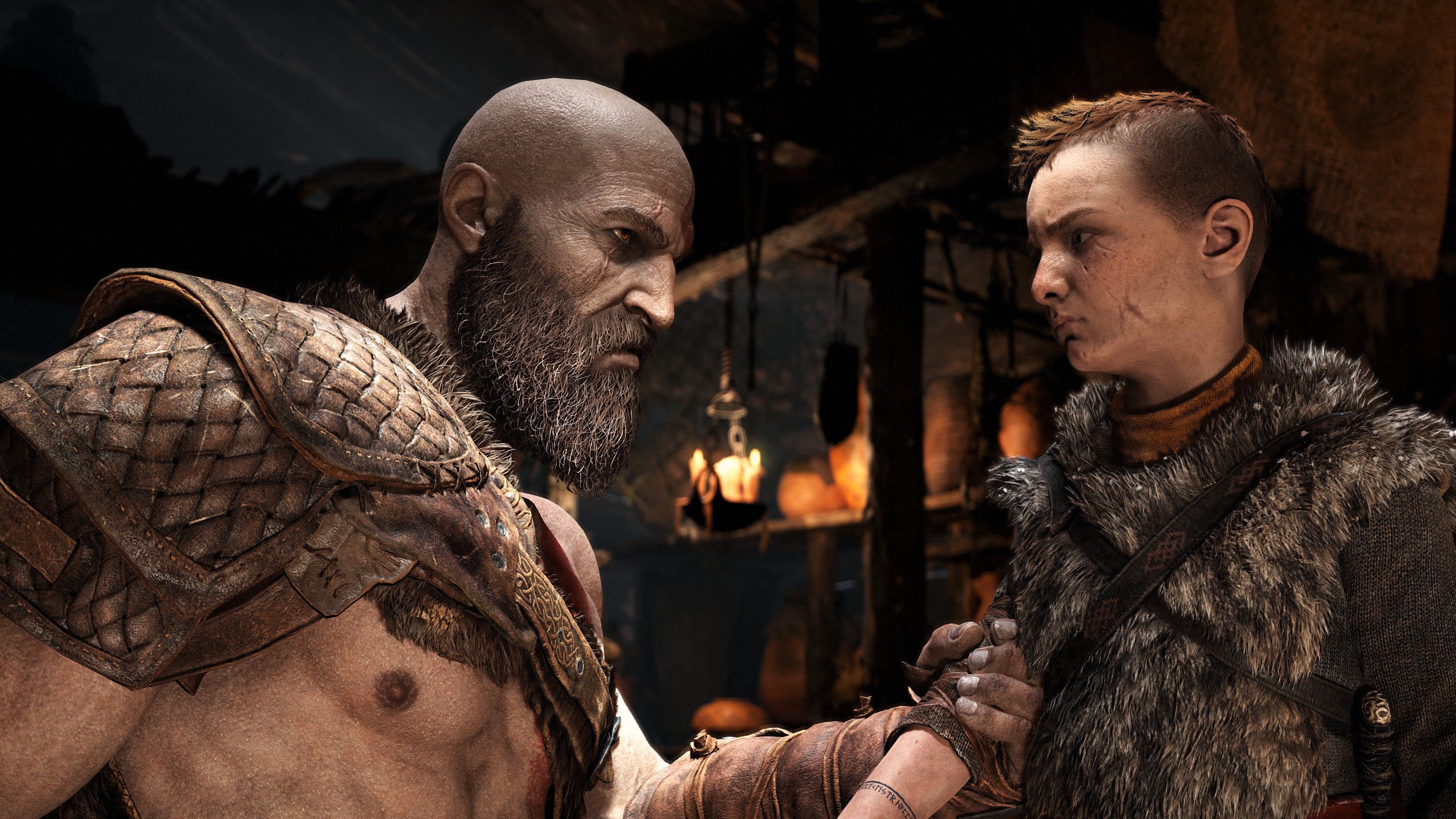 Kratos holds his son's arm in a screenshot from God of War's PC edition.