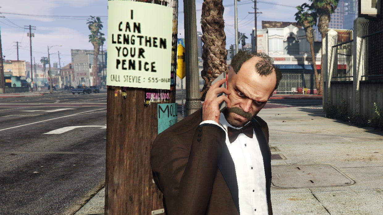 Trevor on the phone beneath a flier advertising to 'lengthen your penice' in a Grand Theft Auto 5 screenshot.