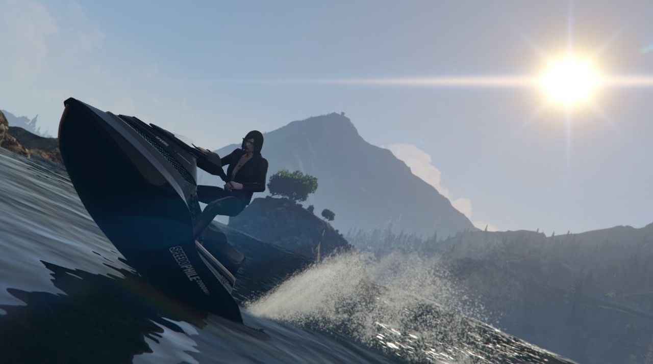 The player character in GTA online rides a jet ski, the sun and mountains framed behind them