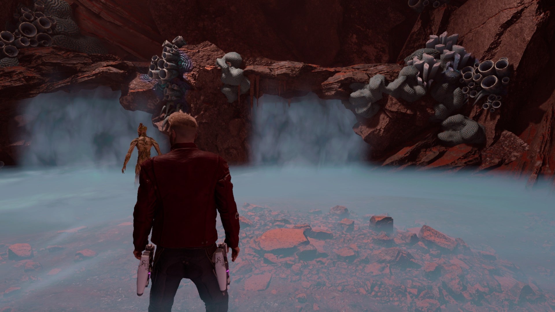 Star-Lord standing in the foggy cave with Groot just in front
