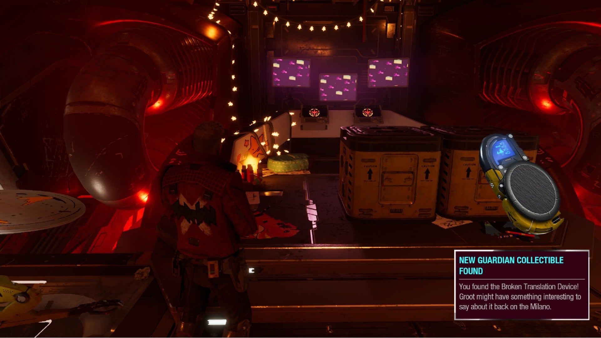 Star-Lord stands in Nikki's hideout, pink screens up ahead with crates on the floor nearby.