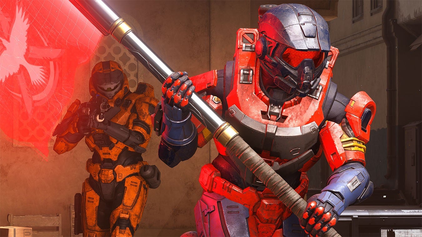 Halo Infinite - A player in red spartan armor is running and carries a red flag while a player in orange behind them holds a gun at the ready