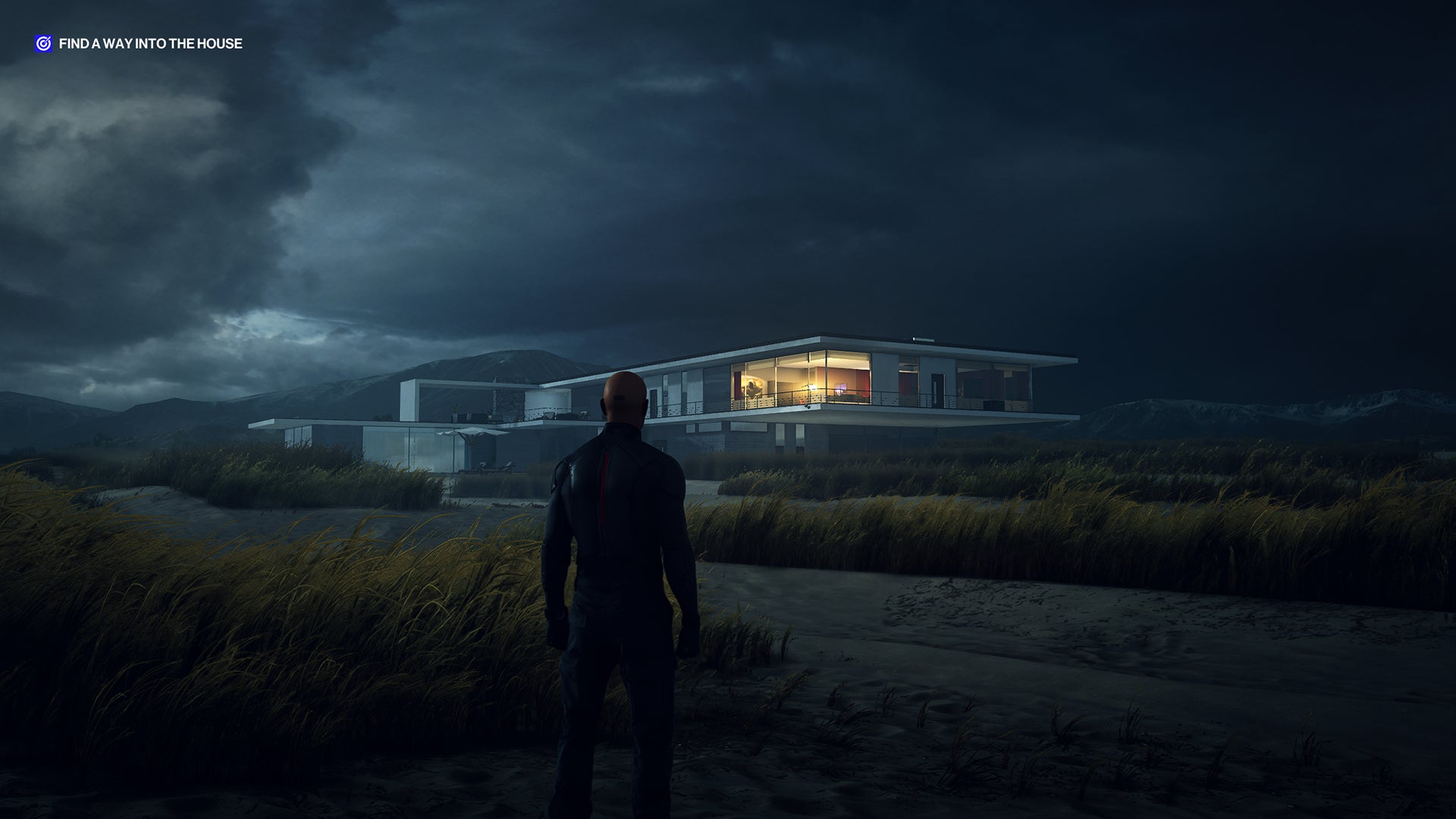 A screenshot of Ian Hitman standing on the beach at Hawke's Beach, looking towards the modern seaside home, at night.