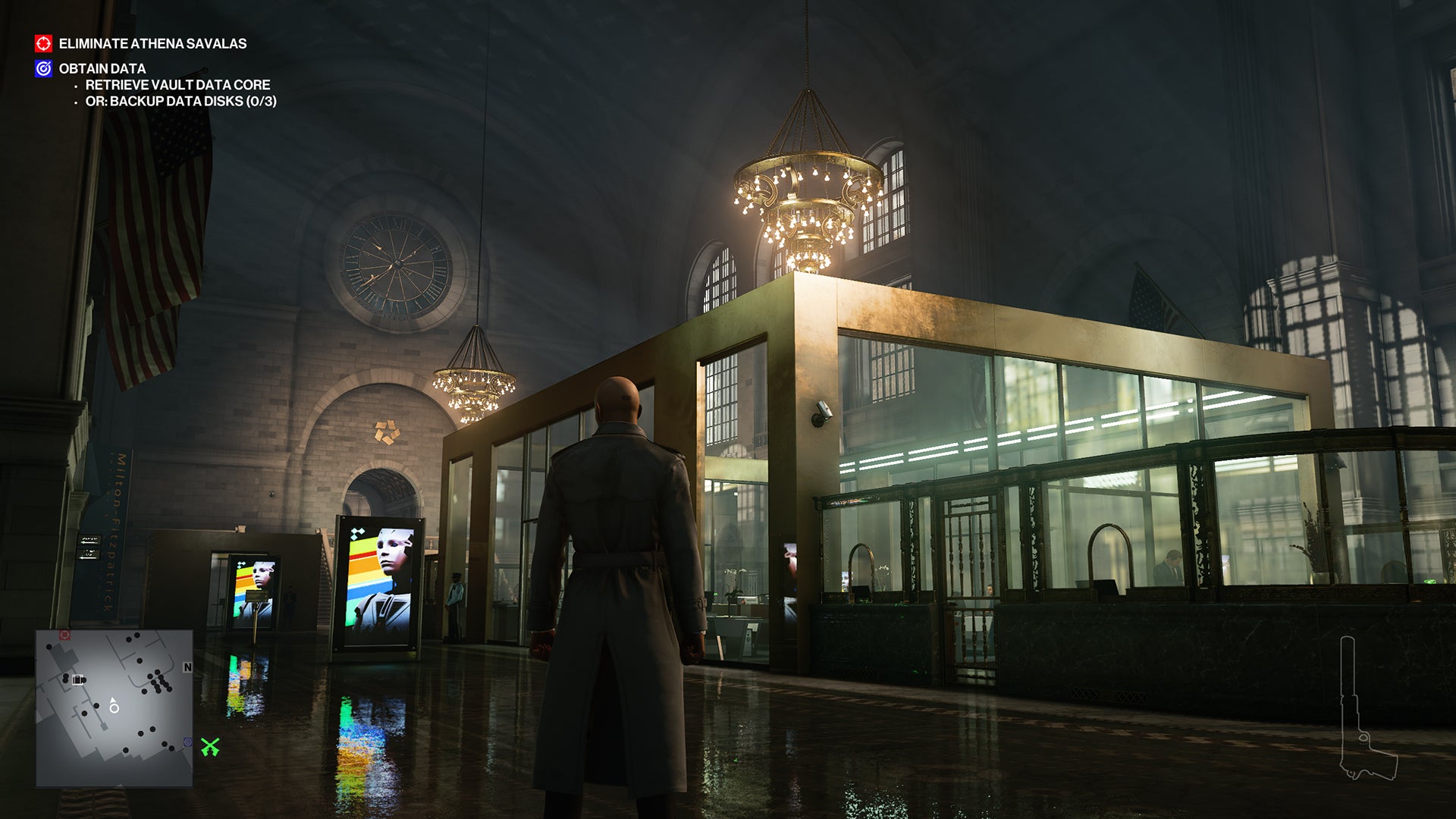 A screenshot showing the bank in the New York level of Hitman 2, where Ian Hitman stands in a beige trenchcoat and looks at the secure teller area.