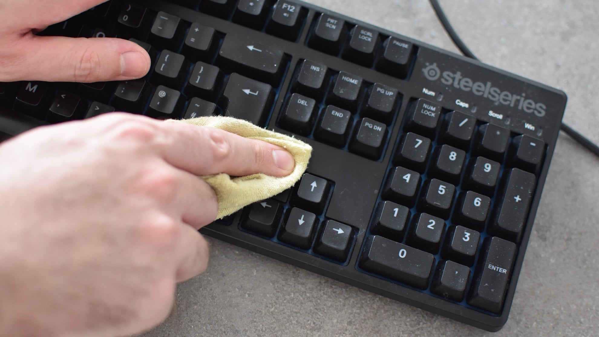A keyboard being cleaned with a cloth.