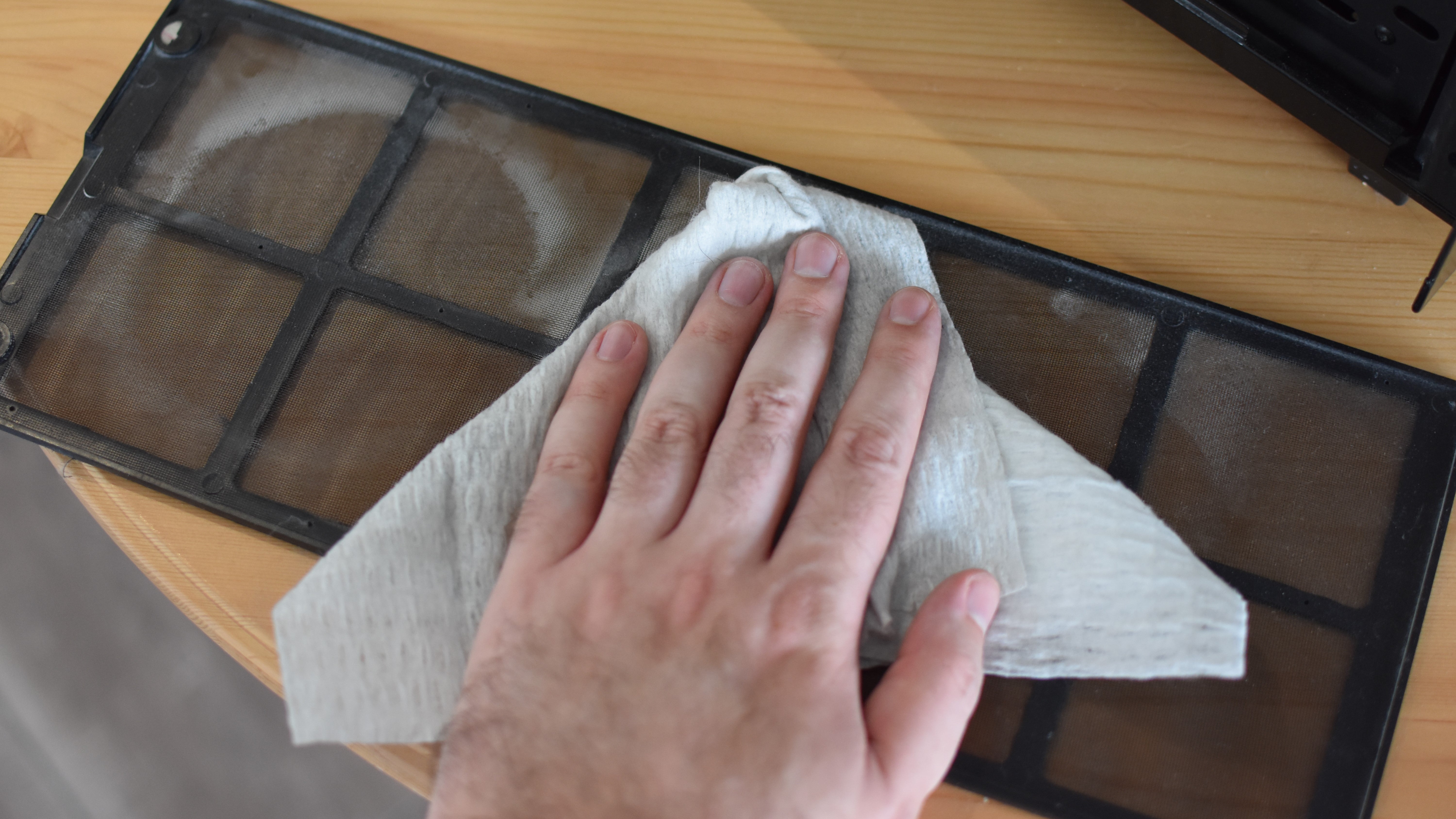 An image of a PC case dust filter being cleaned.
