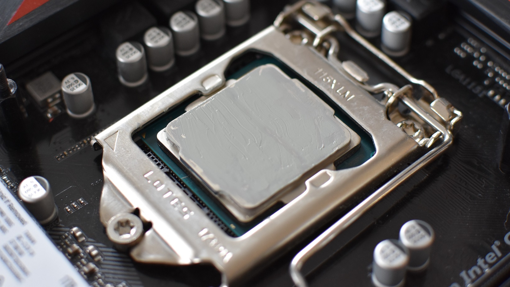 An Intel CPU covered in a thin layer of thermal paste.