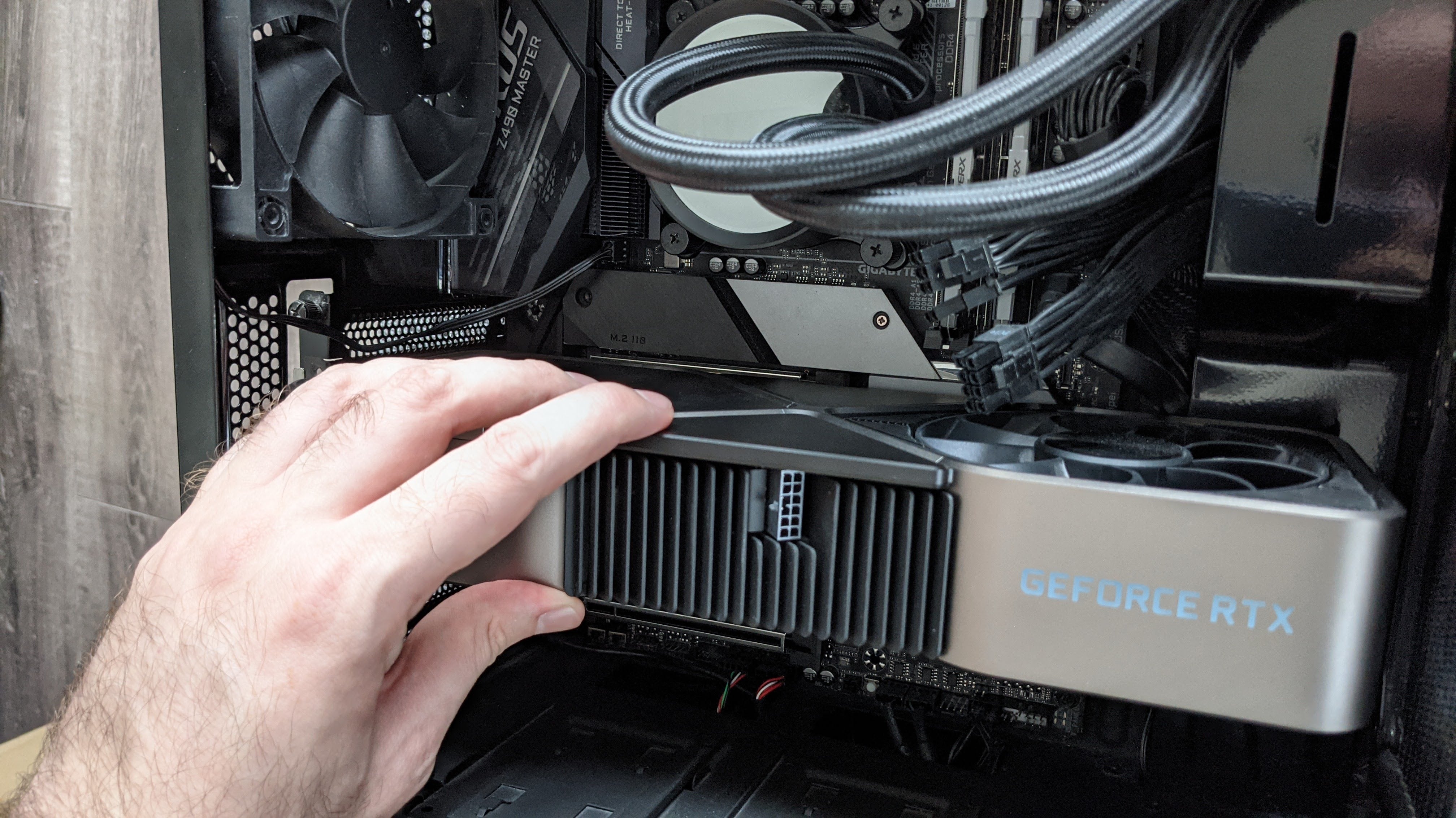 An Nvidia RTX 3090 graphics card being inserted into a motherboard's PCIe x16 slot.