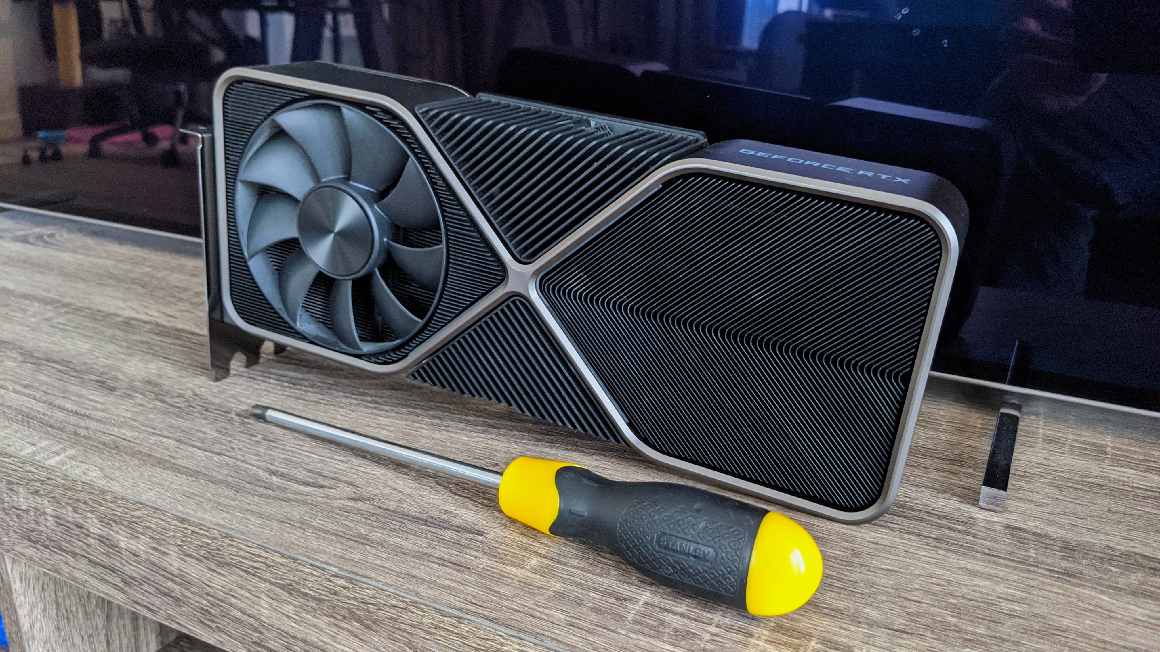 An Nvidia GeForce RTX 3090 Founders Edition on a table, next to a screwdriver.